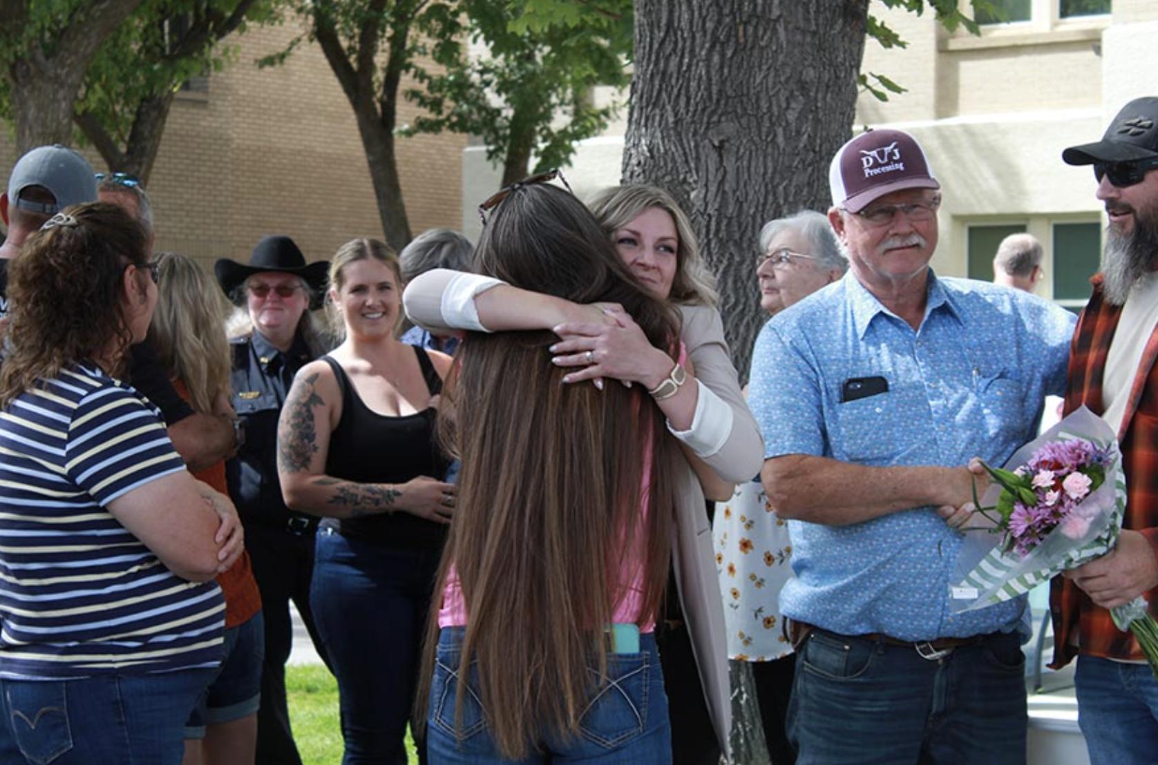 Lentz embracing loved ones after speaking about her story of surviving a kidnapping.