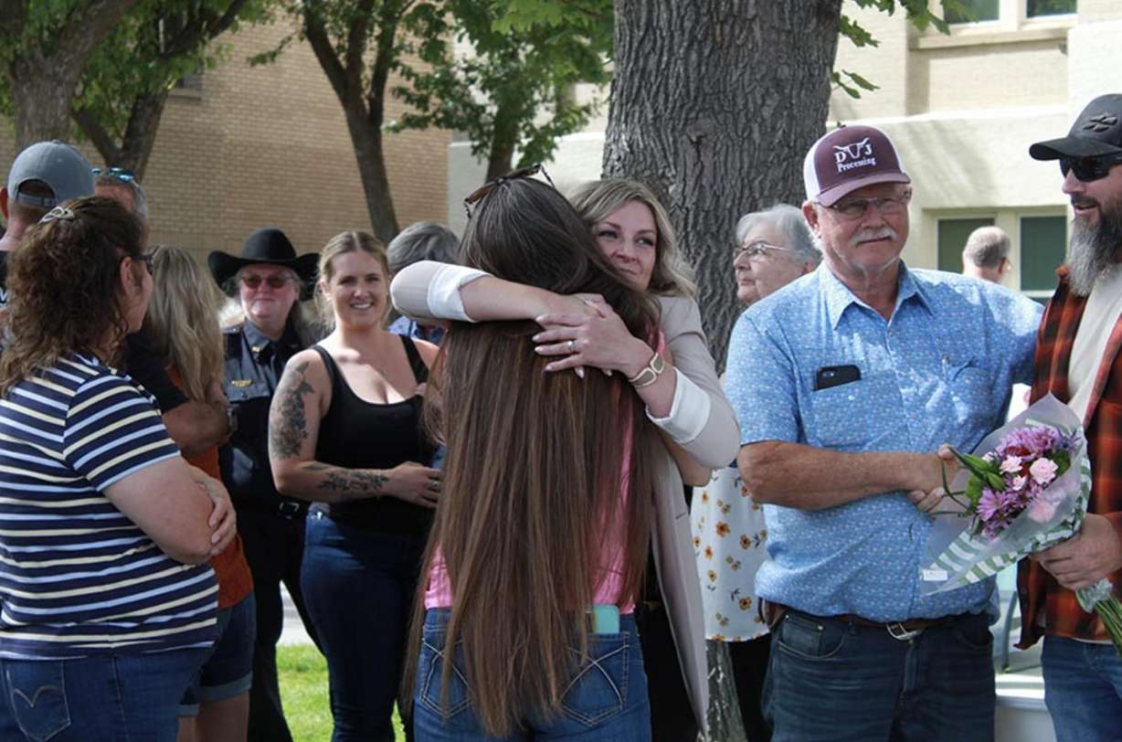 Lentz embracing loved ones after speaking about her story of surviving a kidnapping.