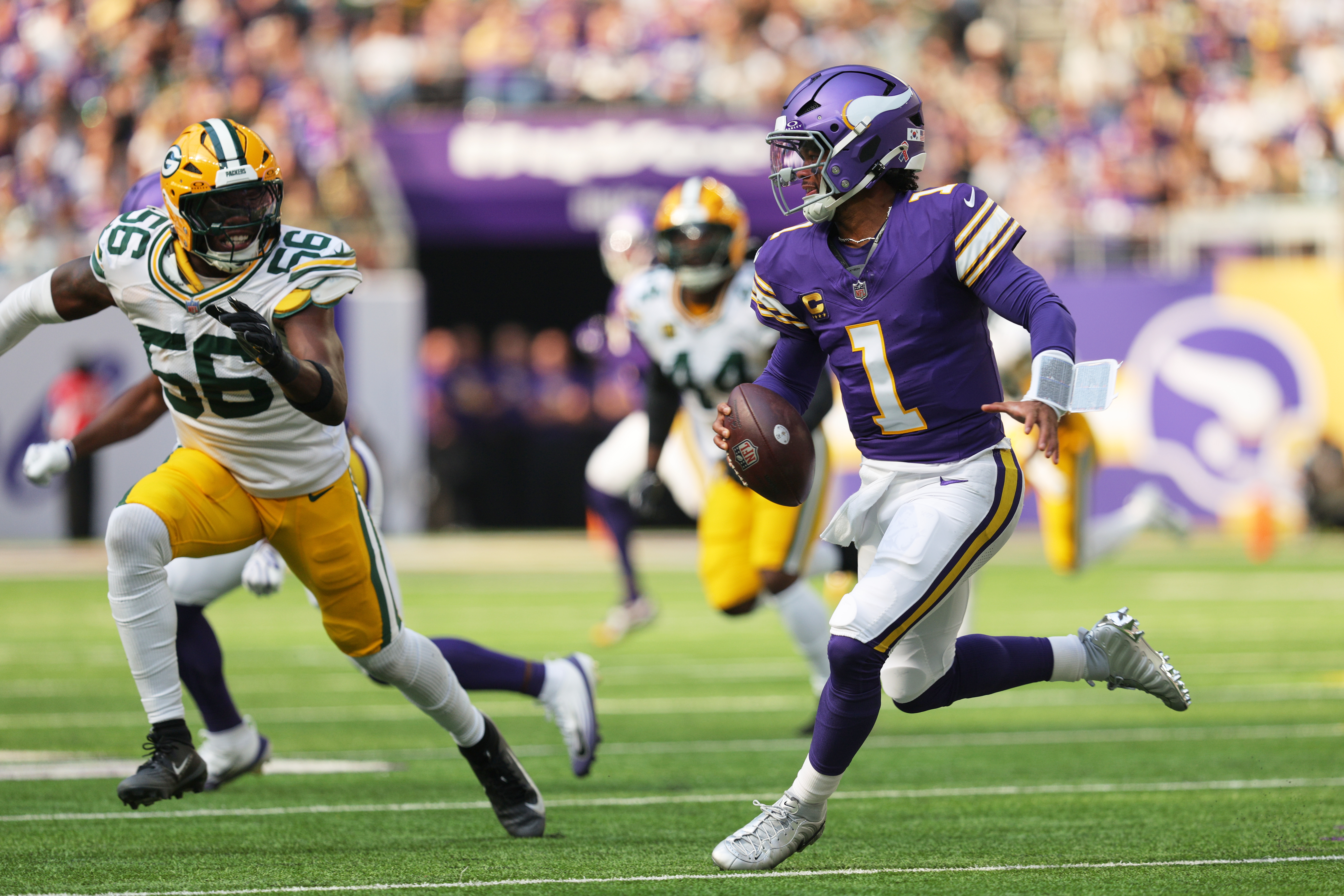 Minnesota Vikings quarterback Kyler Murray (1) scrambles under pressure from Green Bay Packers linebacker Edgerrin Cooper (56) during the first half of an NFL football game, Sunday, Sept. 13, 2026, in Minneapolis, Minn. 