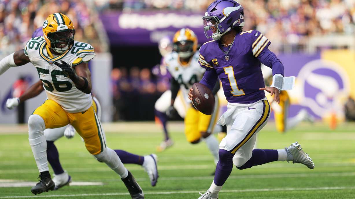 Minnesota Vikings quarterback Kyler Murray (1) scrambles under pressure from Green Bay Packers linebacker Edgerrin Cooper (56) during the first half of an NFL football game, Sunday, Sept. 13, 2026, in Minneapolis, Minn.