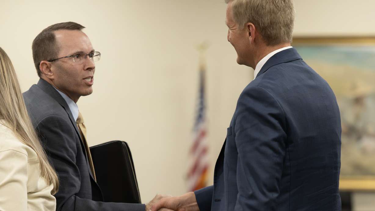 Justice nominee Judge Matthew Bell shakes hands with Michael Menssen after their confirmation hearings at the Capitol in Salt Lake City on Monday.
