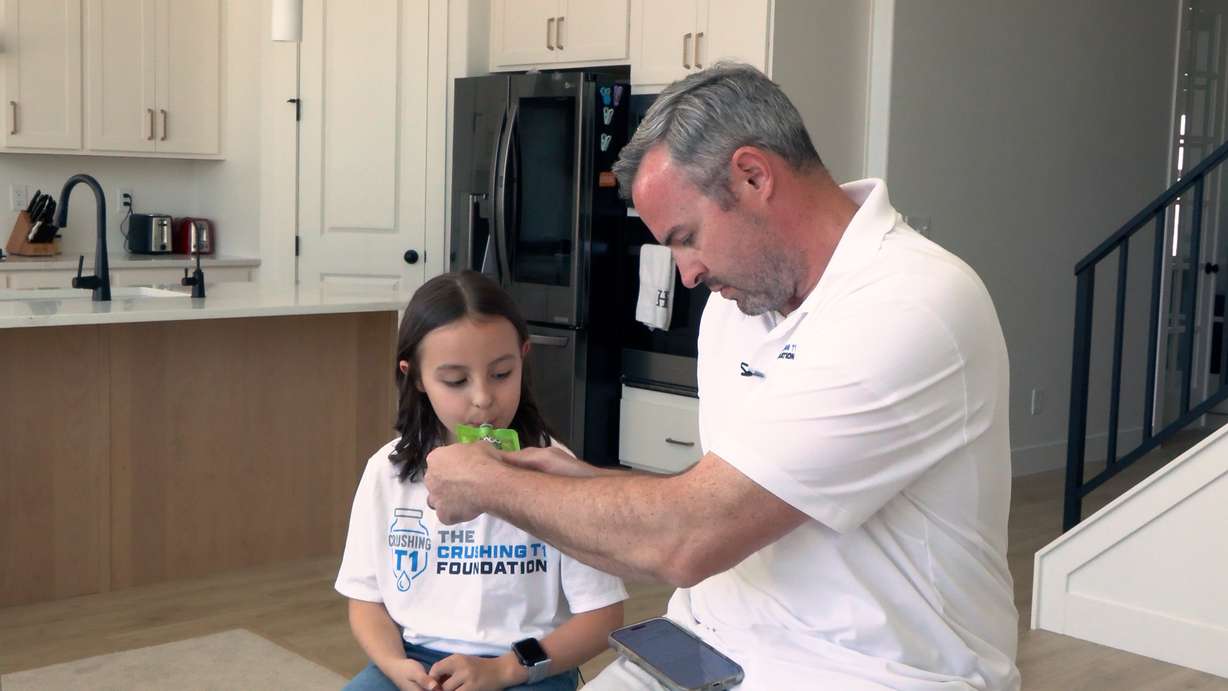 Devin Holt helps his daughter, Caroline, manage her Type 1 diabetes at home.
