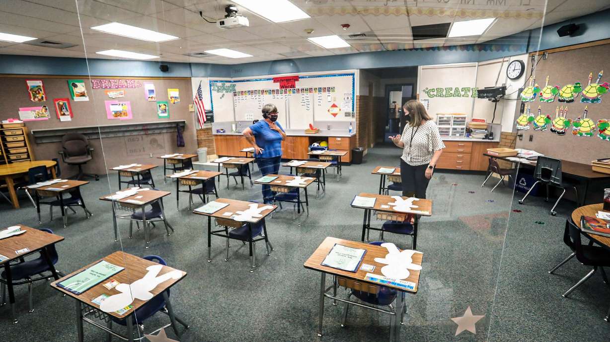 A large sheet of clear plastic hangs from Cathy Sullivan’s kindergarten classroom at Westvale Elementary School in West Jordan as she talks with Principal April Gaydosh, right, on Aug. 19, 2020. Statewide assessments show Utah students have improved in English Language Arts and math, with science results reaching record highs.