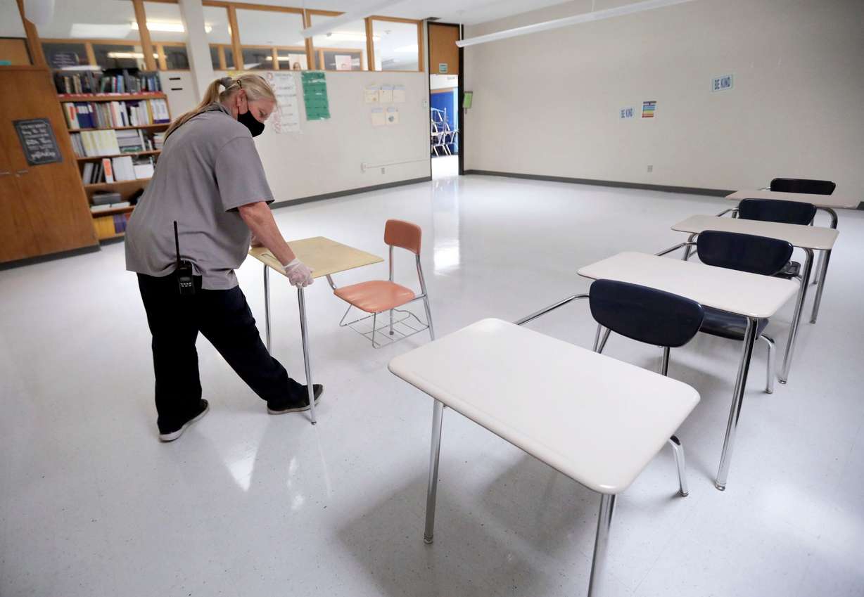 Stephanie Harrill, Skyline High School custodian, sets up desks in a cleaned classroom to get ready for the start of school at Skyline High School in Millcreek on July 23, 2020.