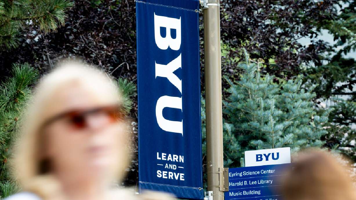 People walk by BYU banners on the campus of Brigham Young University in Provo on Thursday, Aug. 21, 2025. Police said BYU employee Vincent Stanley Benfell was hit by a car earlier this month.