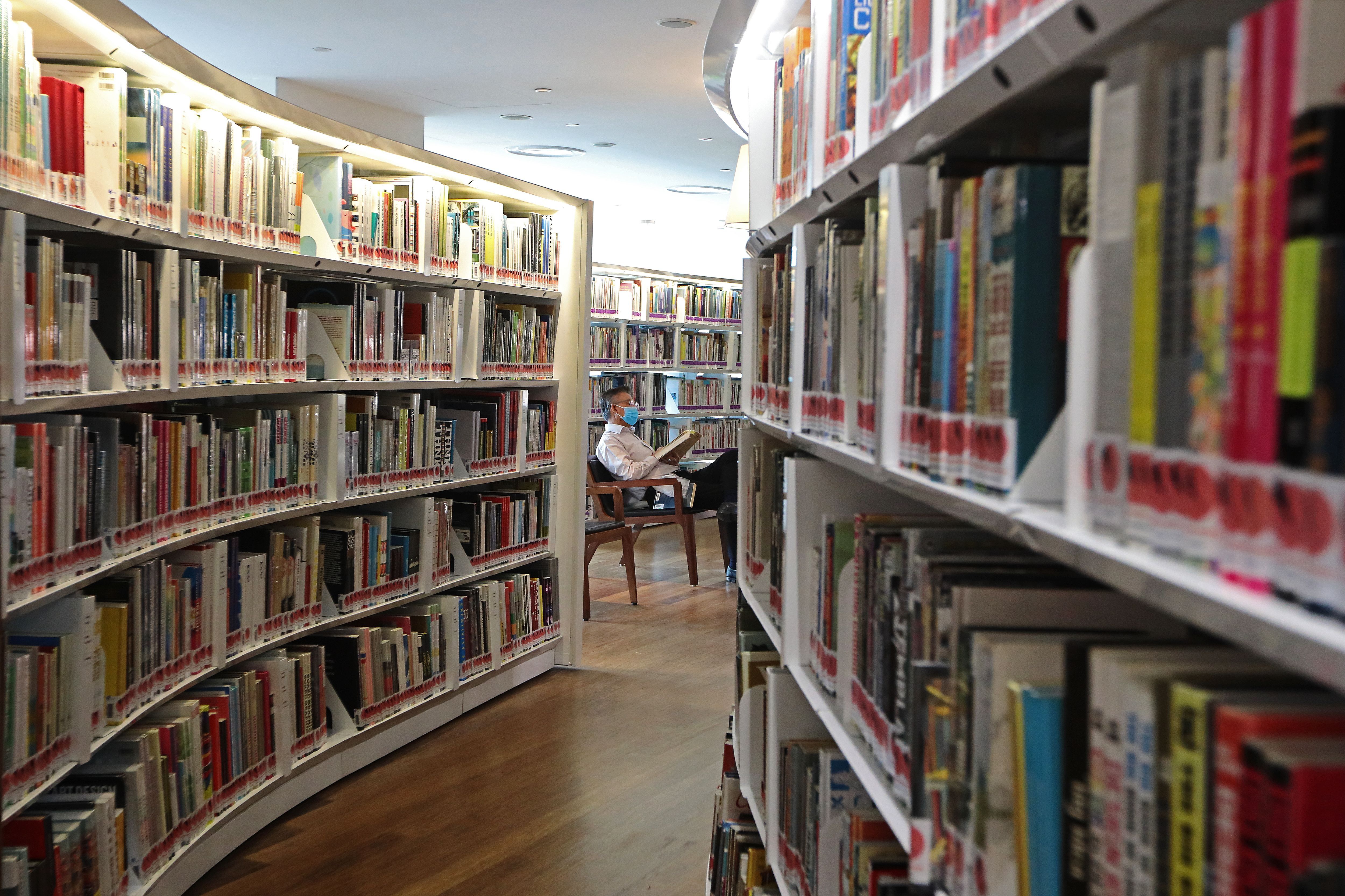 A man reads a book in a public library in Singapore on March 19, 2020. The nation is nudging people towards reading in an effort to combat "brain rot."