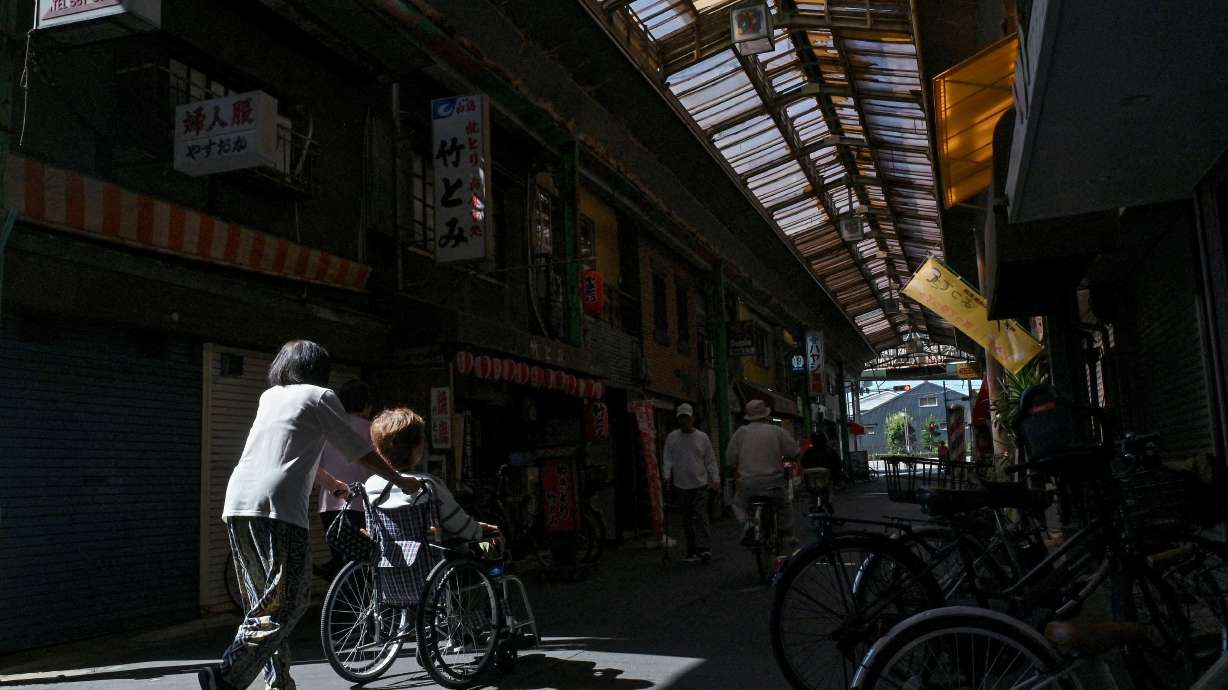 An elderly woman being pushed through the Tsurumibashi "shotengai," an old covered shopping street in the Nishinari ward of Osaka, Japan, on Oct. 1, 2025. For the first time, Japan now has over 100,000 centenarians.