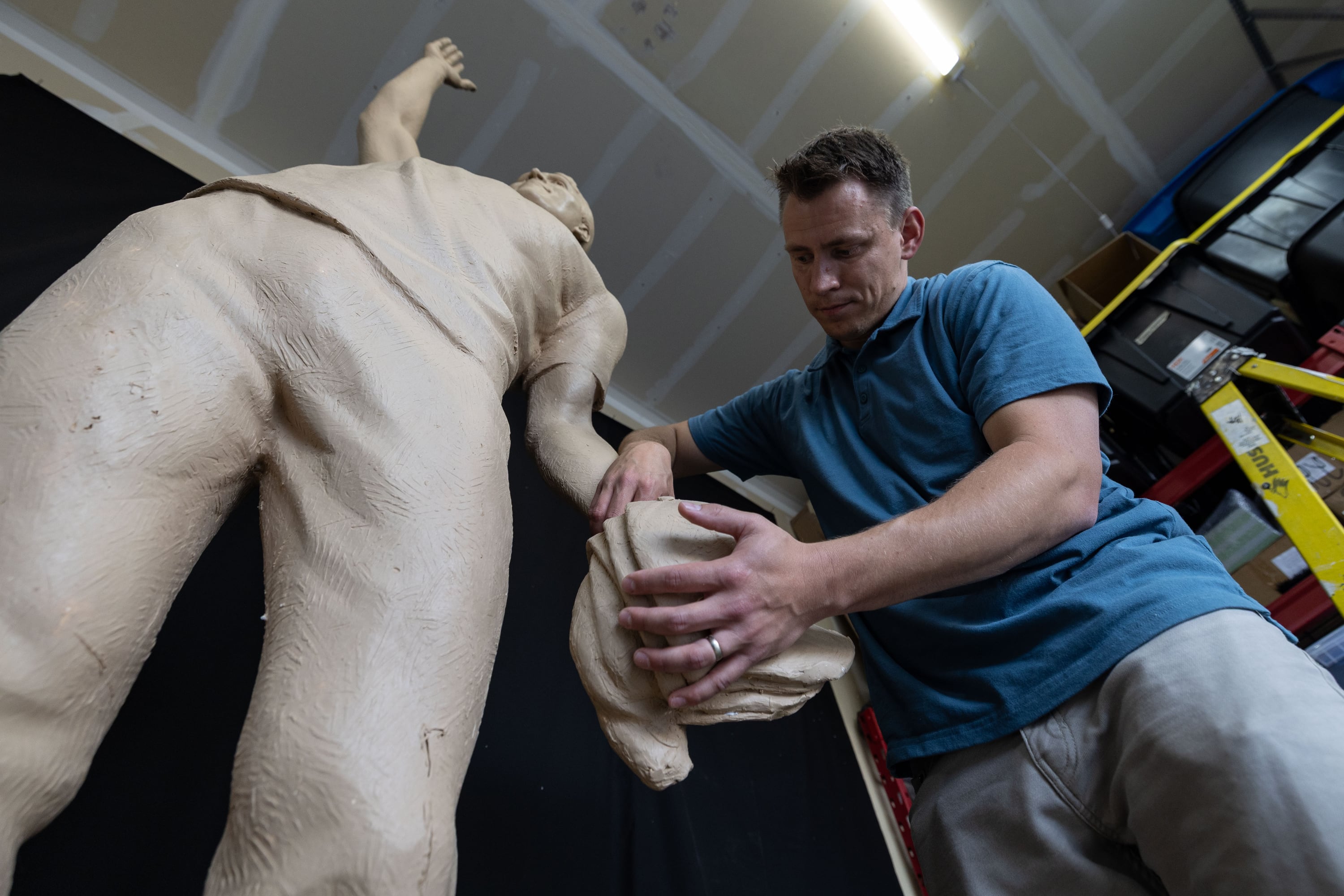 Quintin McCann works on his original clay mold of Charlie Kirk, fixing it at his home in Eagle Mountain after the bronze molding process damaged it on Monday. Erika Kirk decided what the statue should represent.