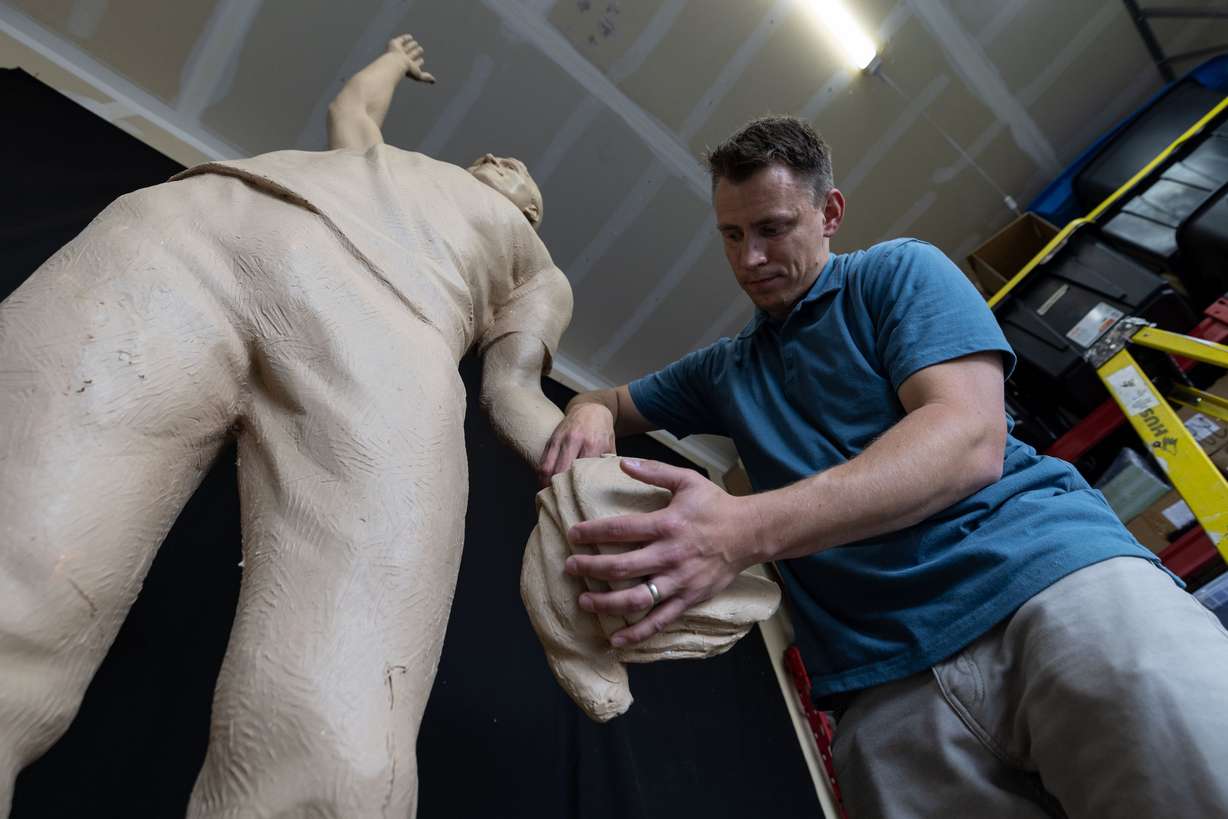 Quintin McCann works on his original clay mold of Charlie Kirk, fixing it at his home in Eagle Mountain after the bronze molding process damaged it on Monday. Erika Kirk decided what the statue should represent.