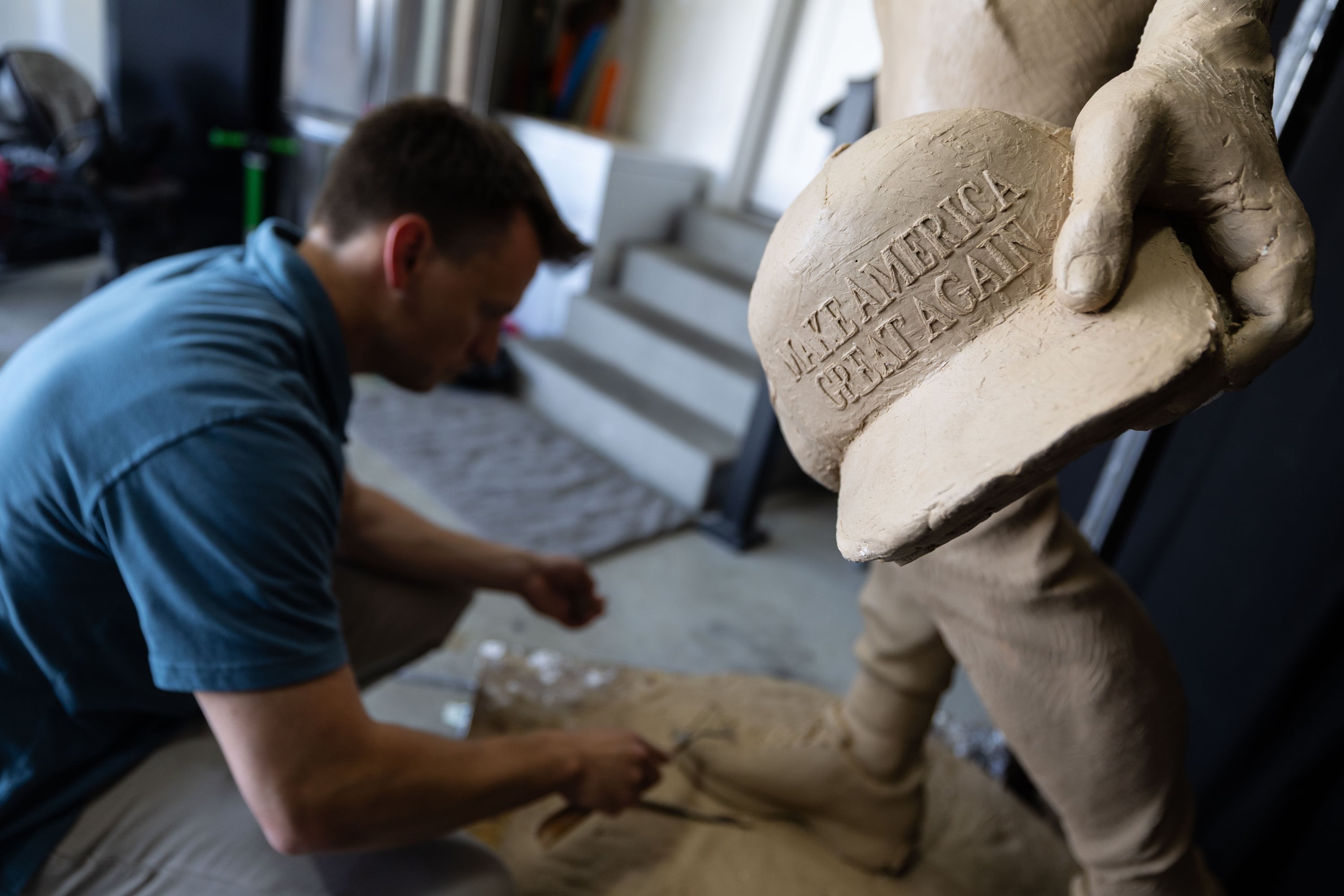 Quintin McCann works on his original clay mold of Charlie Kirk, fixing it at his home in Eagle Mountain after the bronze molding process damaged it on Monday. The statue was defaced in Arizona recently.