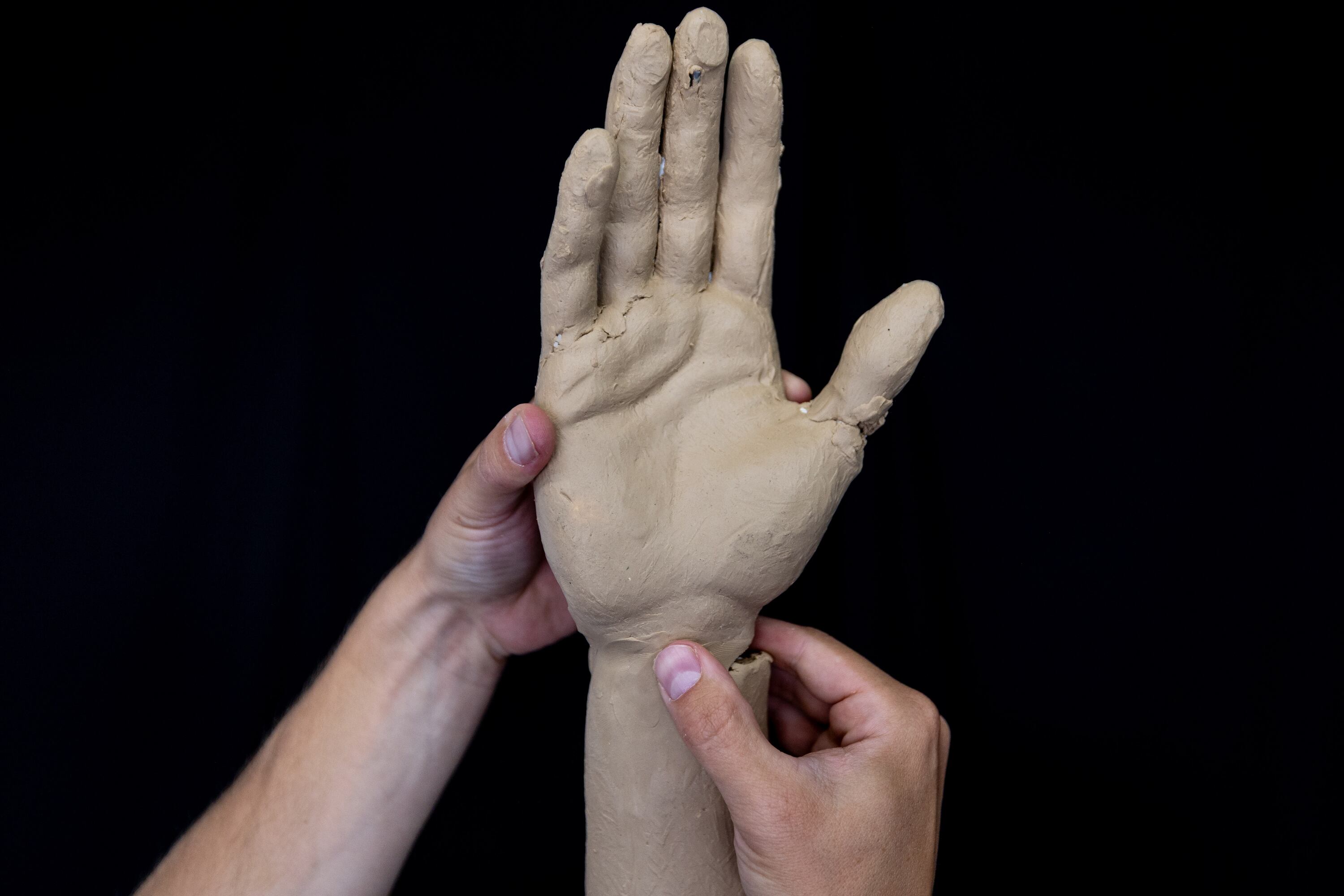 Quintin McCann works on his original clay mold of Charlie Kirk, fixing it at his home in Eagle Mountain after the bronze molding process damaged it on Monday. Divisions over Kirk's death reached an all-time high on the anniversary of his murder on Thursday.