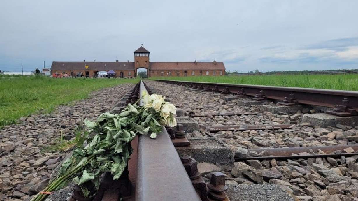 White flowers lay on the train tracks that lead into Auschwitz II-Birkenau death camp on May 14, 2023. A Holocaust survivor will be speaking at the University of Utah on Tuesday.