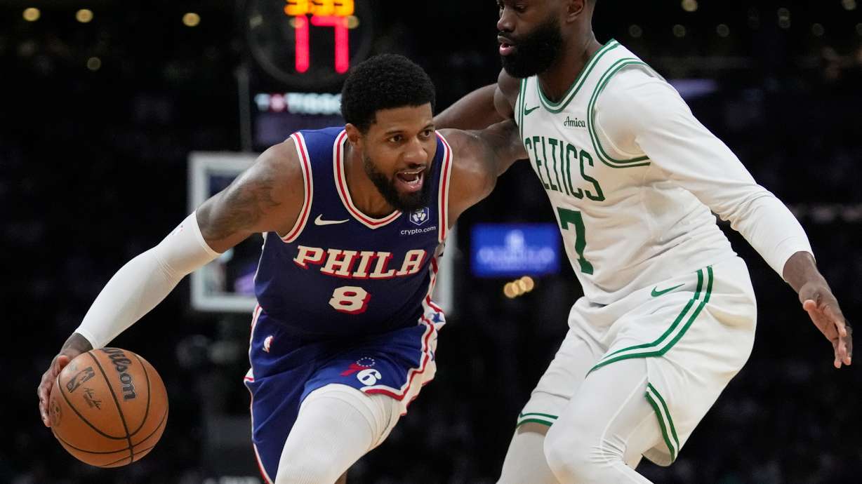 FILE - Philadelphia 76ers forward Paul George (8) drives around Boston Celtics guard Jaylen Brown (7) during the second half in Game 1 of a first-round NBA playoffs basketball game, Sunday, April 19, 2026, in Boston.