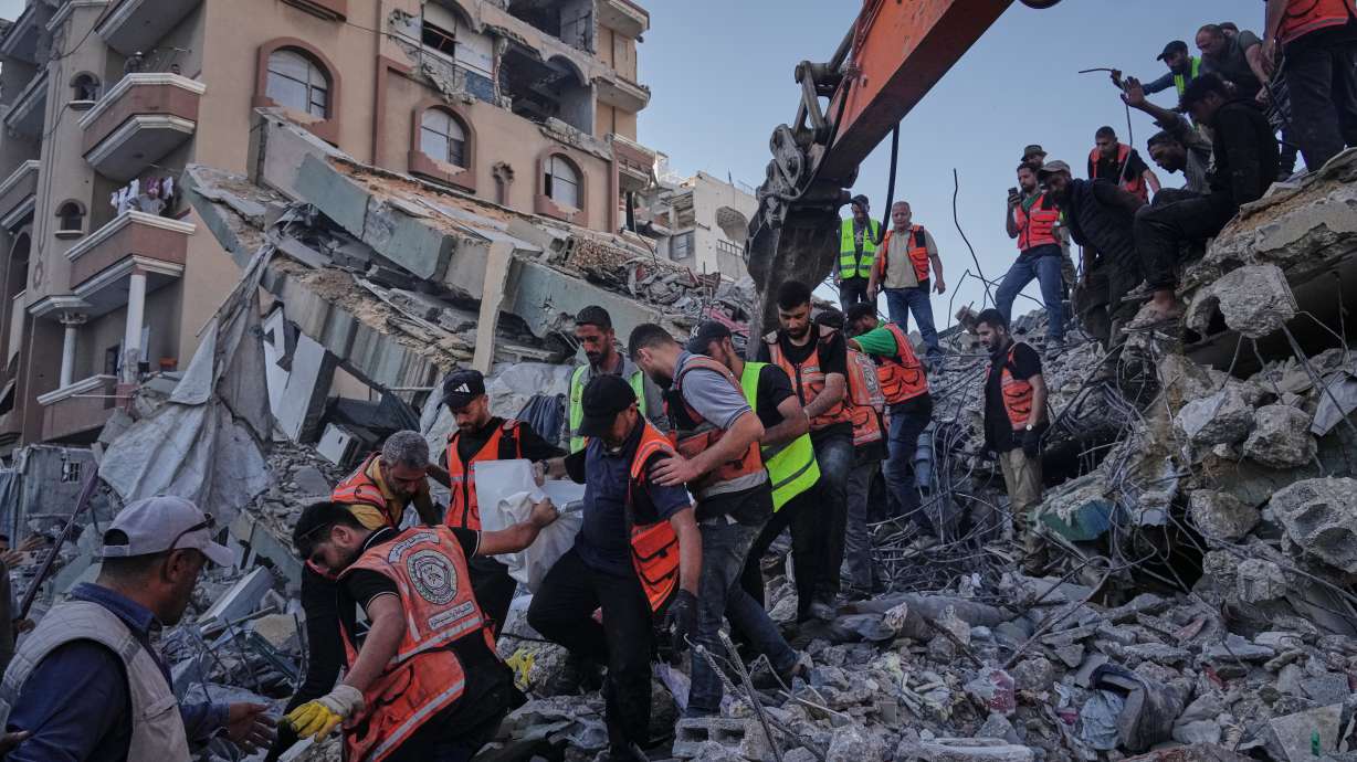 Palestinian civil defense crews carry a body from the rubble of a collapsed building that housed displaced Palestinians and was heavily damaged during the Israel-Hamas war, in Gaza City, Wednesday. Nineteen people were killed in the collapse.