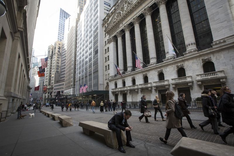 People walk by the New York Stock Exchange in New York's financial district March 11, 2014.