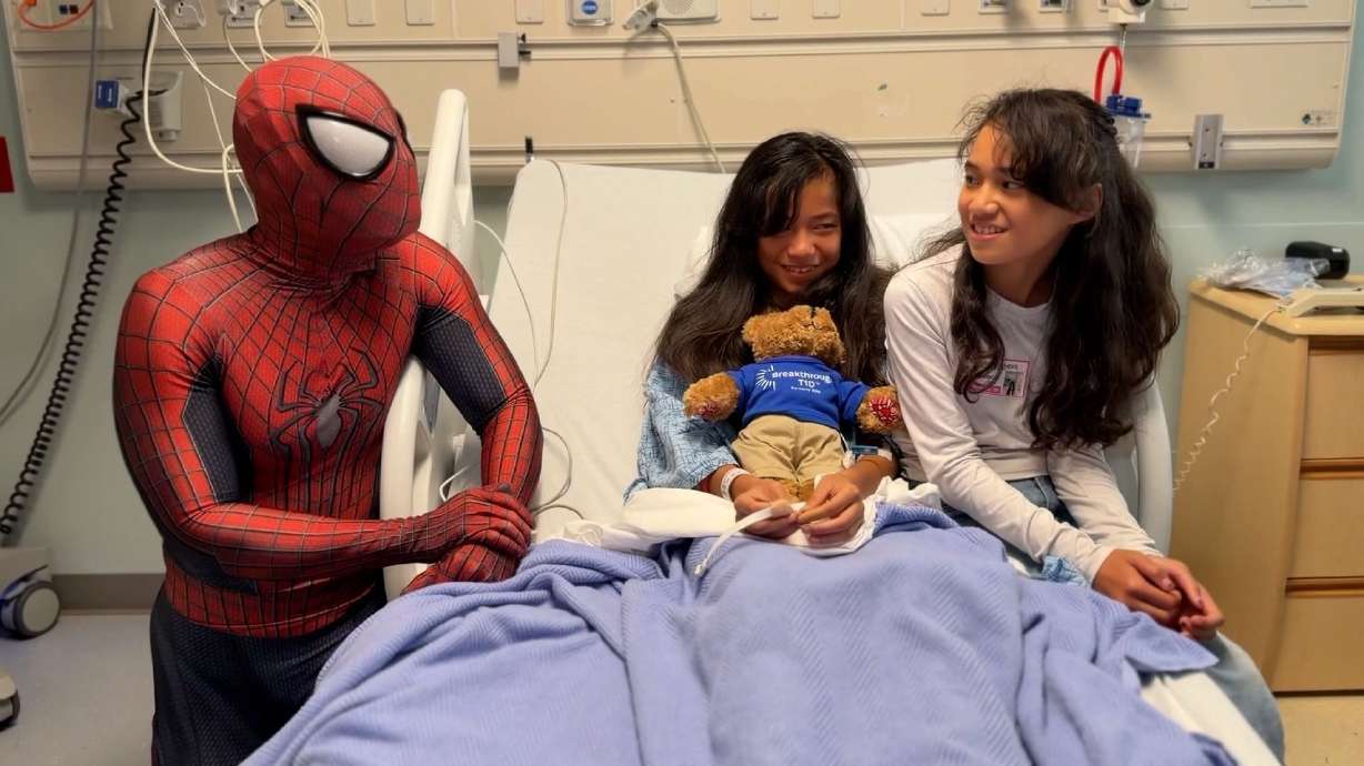 Ricky Mena, dressed as Spider-Man, visits with a young patient at Kaiser Permanente Roseville. Mena has spent more than a decade visiting children in hospitals and their homes.