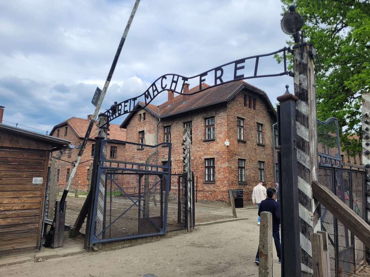 The iron gate over the entrance to Auschwitz I, which reads "Arbeit macht frei." The German phrase is loosely translated as "Work sets you free."