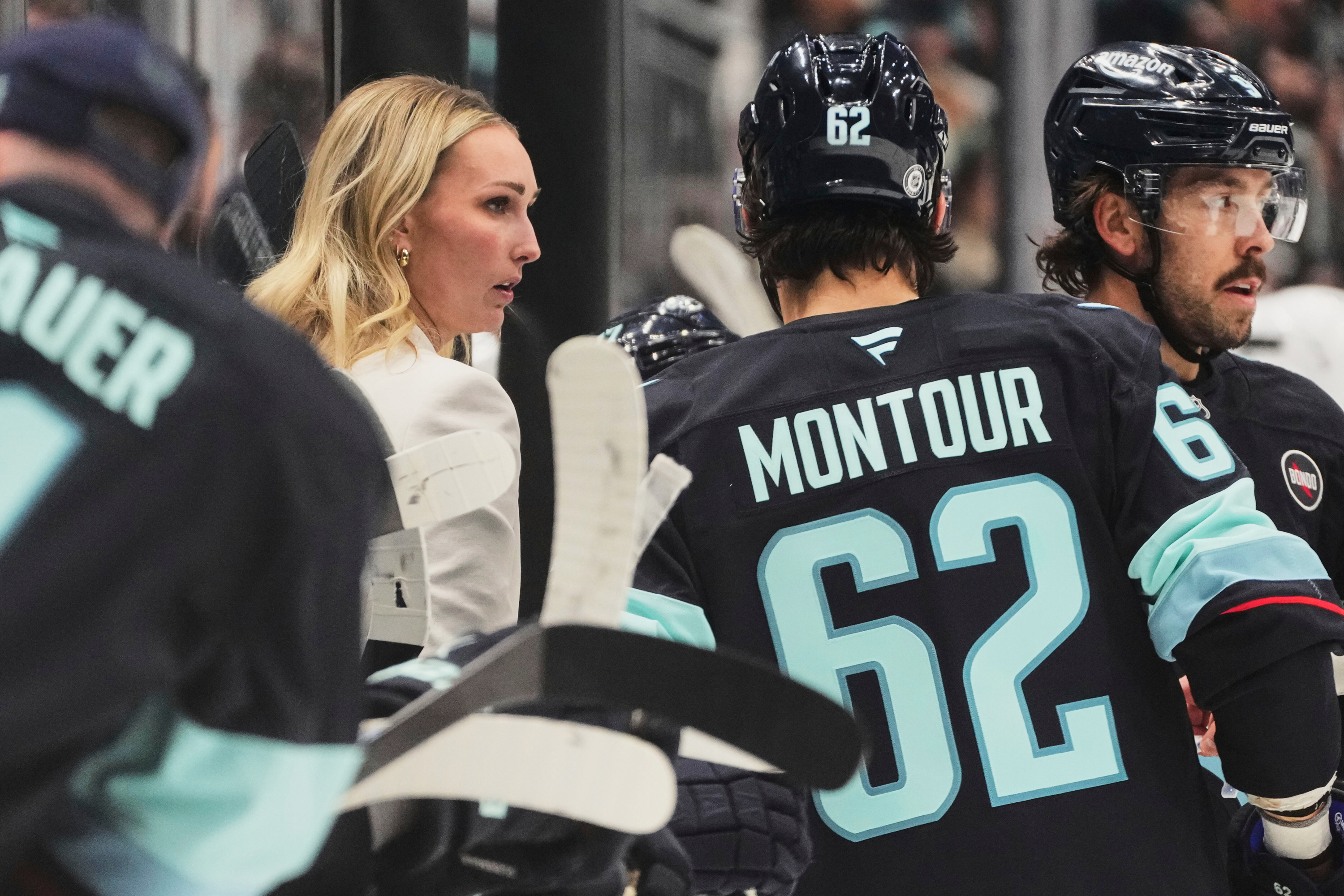 FILE - Seattle Kraken assistant coach Jessica Campbell talks with defenseman Brandon Montour (62) during a timeout in the third period of an NHL hockey game against the Los Angeles Kings, April 15, 2025, in Seattle. 