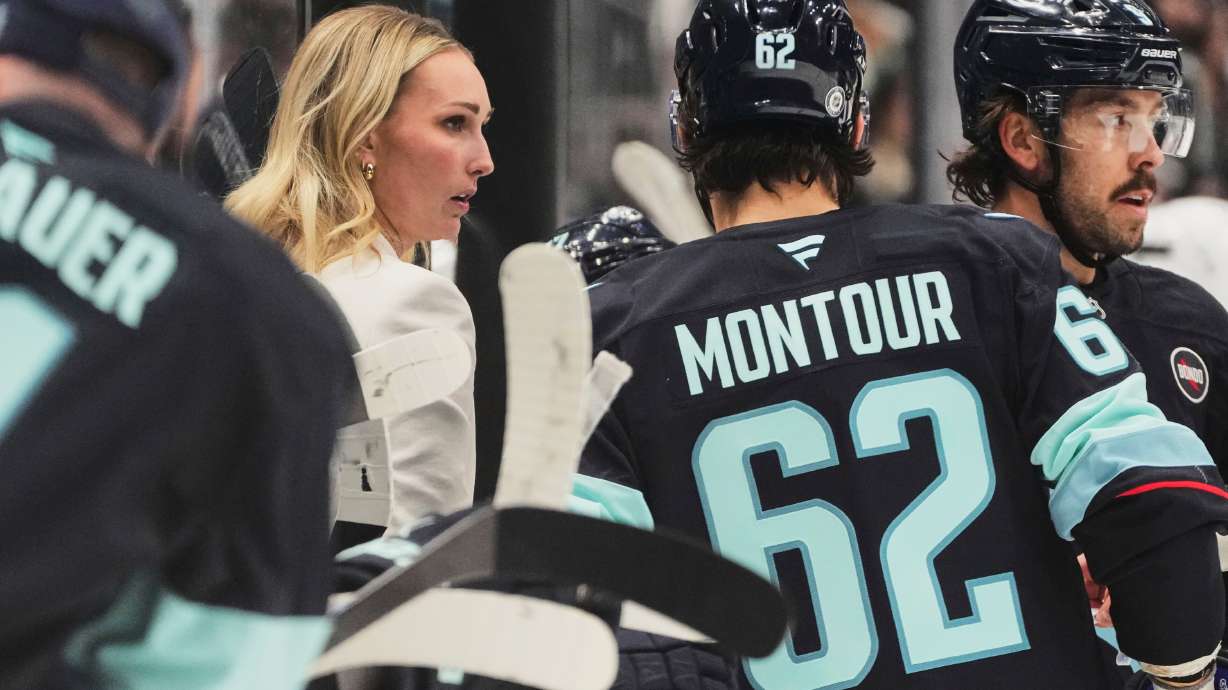 FILE - Seattle Kraken assistant coach Jessica Campbell talks with defenseman Brandon Montour (62) during a timeout in the third period of an NHL hockey game against the Los Angeles Kings, April 15, 2025, in Seattle.
