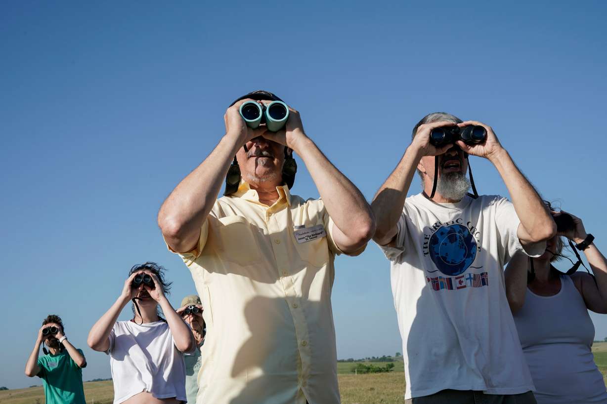 Jason St. Sauver, senior manager for education at Spring Creek Prairie Audubon Center, looks through binoculars while leading a grassland bird tour, June 20, 2023, in Denton, Neb. The Trump administration is being sued over changes to its definition of "harm" under the Endangered Species Act.