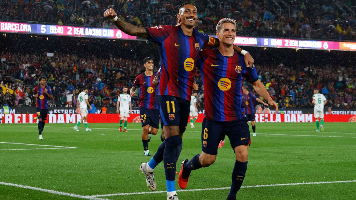 Barcelona's Raphinha celebrates with Gavi, right, after scoring his side's fifth goal from the penalty spot during a Spanish La Liga soccer match between Barcelona and Racing de Santander in Barcelona, Spain, Wednesday, Sept. 16, 2026.