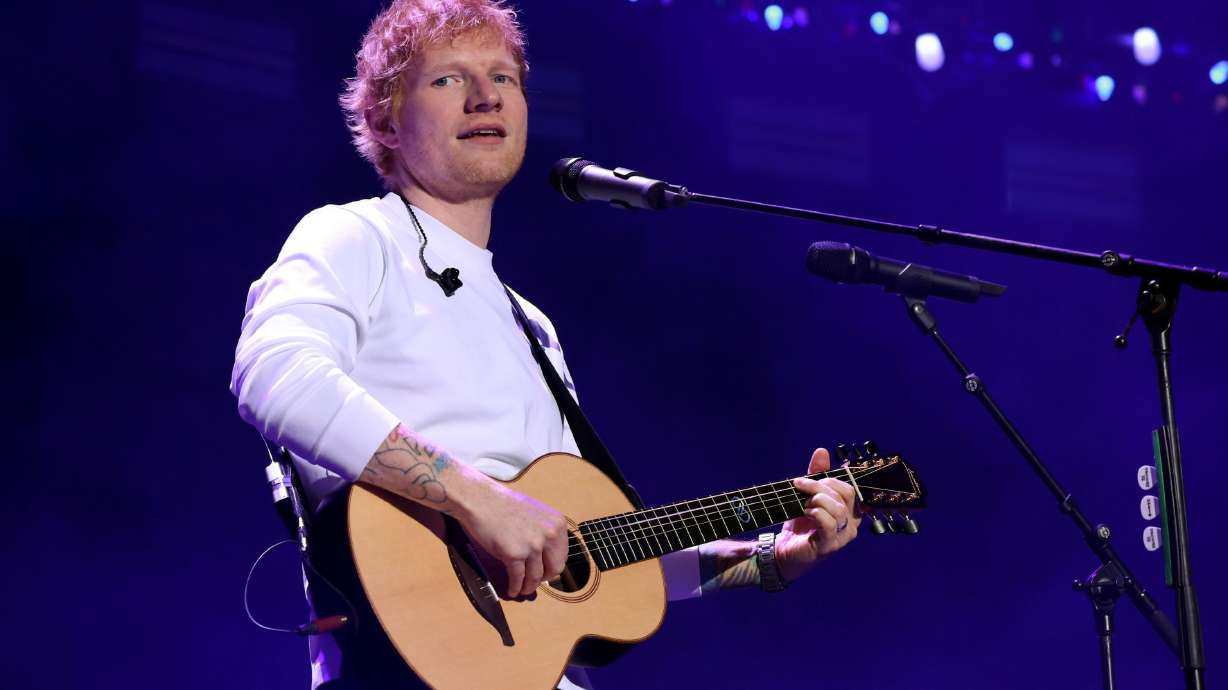 Ed Sheeran performs onstage during iHeartRadio z100's Jingle Ball 2025. The flap over Macklemore at Sheeran's stadium tour has now turned into donations and humanitarian cooperation.