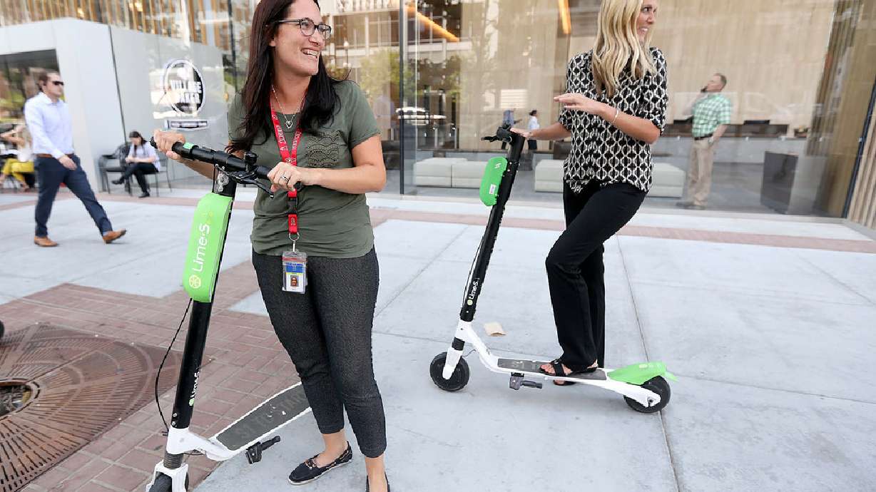 Sarah Baker and Heather Nielson ride Lime electric scooters for the first time in Salt Lake City on Aug. 15, 2018.