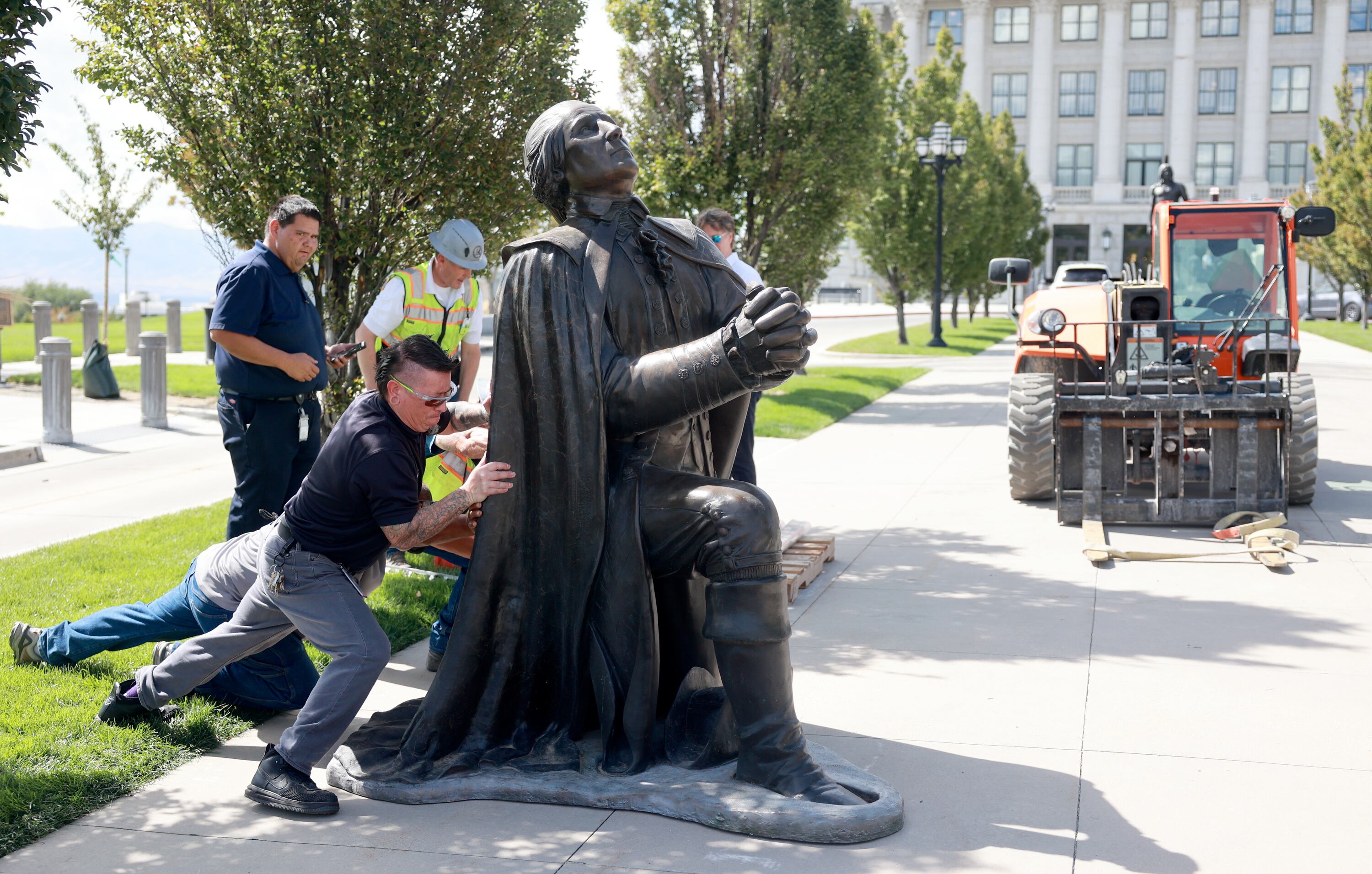 Omer Machuca, maintenance journeyman at the Capitol, helps move Steven Neal’s sculpture of George Washington outside of the Capitol in Salt Lake City on Wednesday.