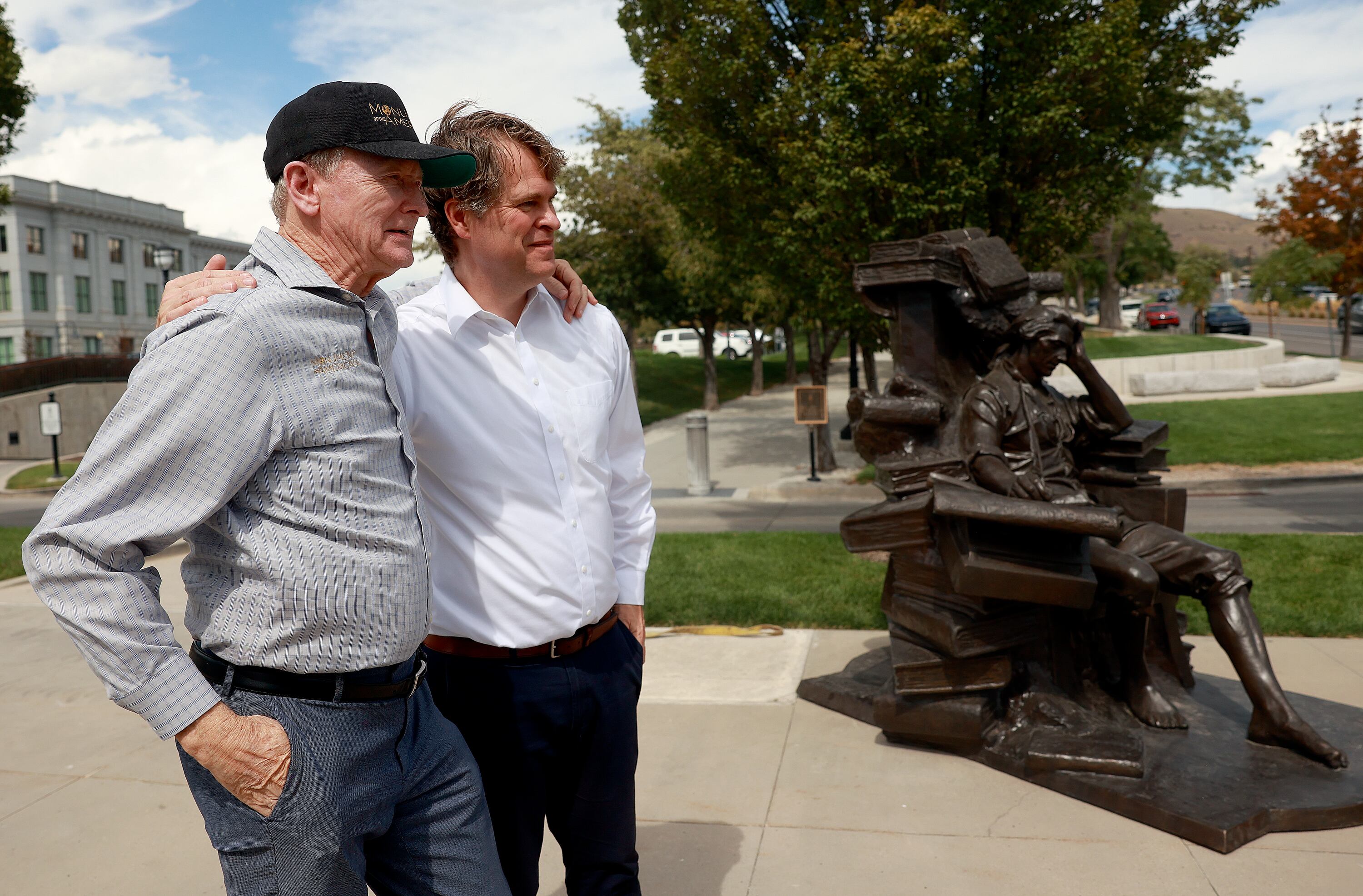 Steven Neal and Michael Hall embrace by their sculptures of George Washington and Thomas Jefferson outside of the Capitol in Salt Lake City on Wednesday.