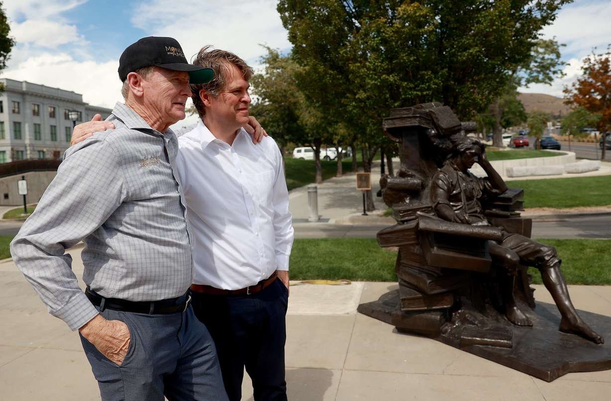 Steven Neal and Michael Hall embrace by their sculptures of George Washington and Thomas Jefferson outside of the Capitol in Salt Lake City on Wednesday.