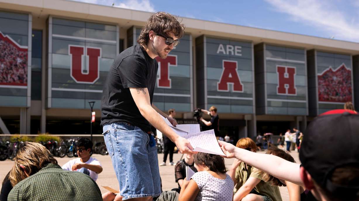 A group of University of Utah students write letters to the university’s dean of college affairs in Salt Lake City on Wednesday. The students say members of the College Republicans should be held accountable for posting a photo of a student, who was later doxxed, who approached them with a cake featuring a joke about Charlie Kirk's murder.