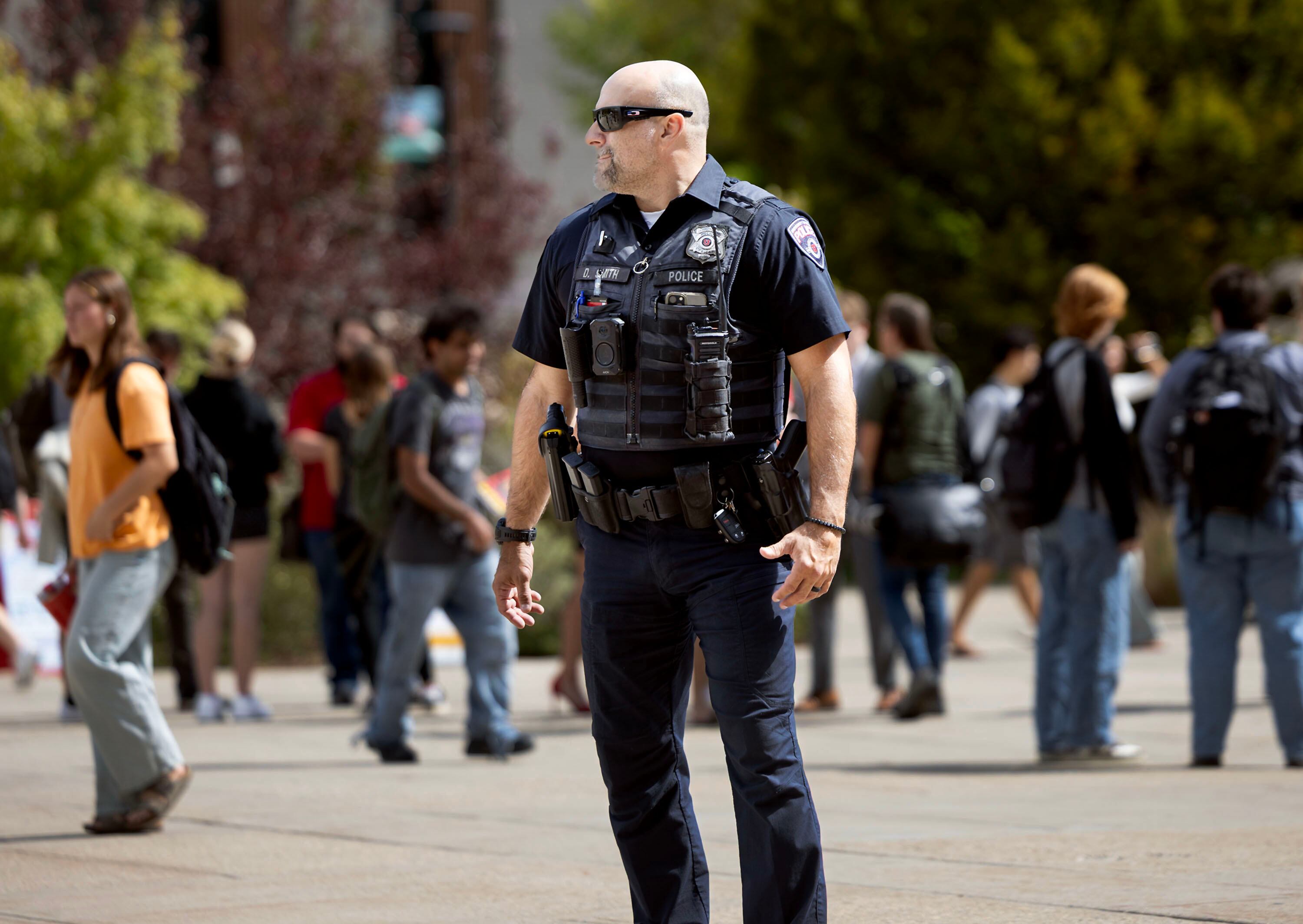 A University of Utah police officer patrols the campus as students write letters to the university’s dean of college affairs at the campus in Salt Lake City on Wednesday. The students say members of the College Republicans should be held accountable for posting a photo of a student that was later doxxed who approached them with a cake featuring a joke about Charlie Kirk's murder.