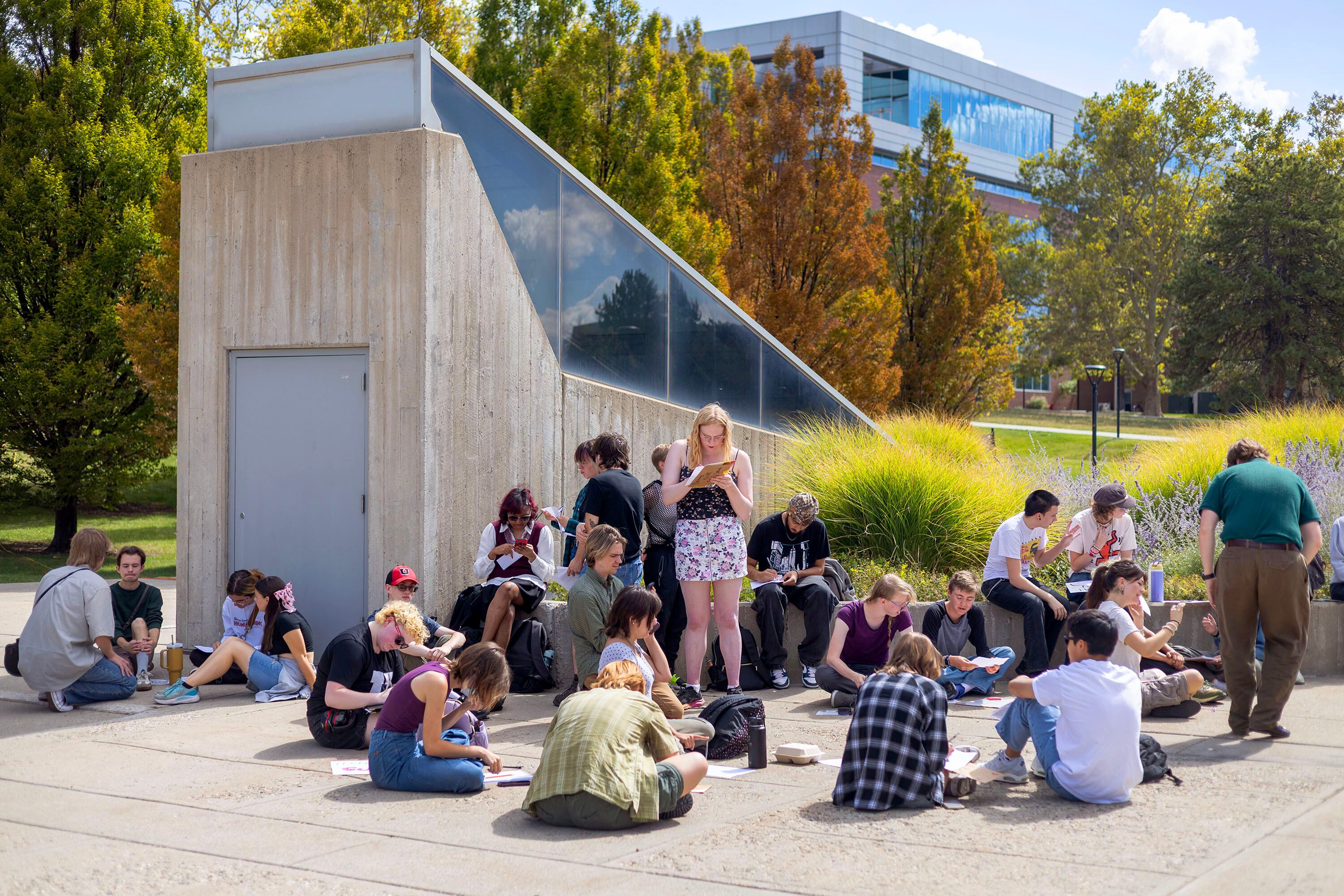 A group of University of Utah students write letters to the university’s dean of college affairs at the campus in Salt Lake City on Wednesday. The students say members of the College Republicans should be held accountable for posting a photo of a student that was later doxxed who approached them with a cake featuring a joke about Charlie Kirk's murder.