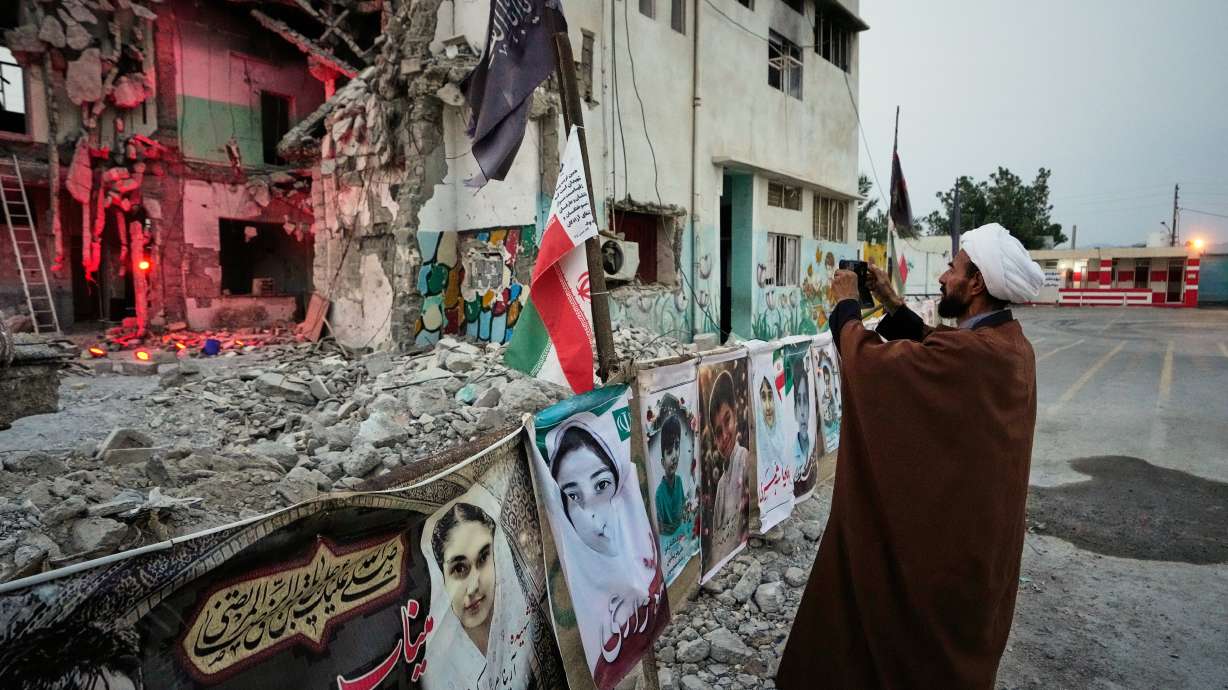 A cleric takes a photograph at the shattered Shajareh Tayyebeh school, which has become a place of mourning and a memorial to those killed in a U.S. airstrike on Feb. 28, in Minab, southern Iran, Sept. 7. U.N.-backed experts cited possible war crimes in U.S. strikes on Iran on Thursday.