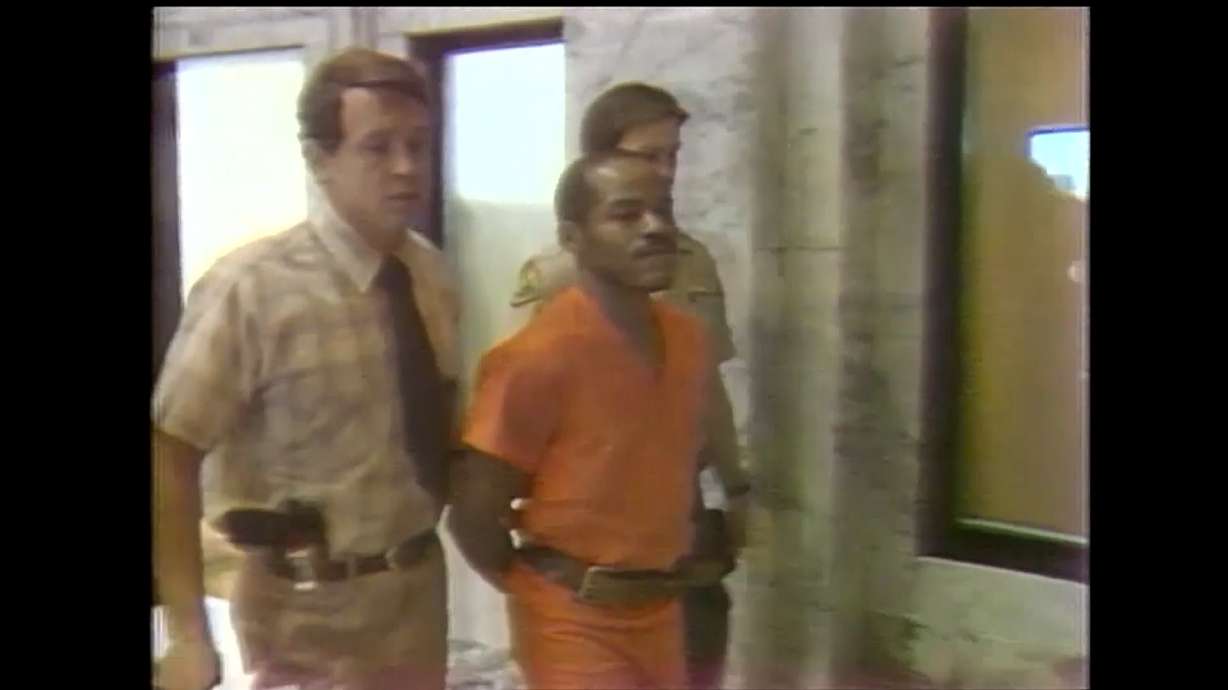 Douglas Carter is escorted in Utah after his arrest for investigation of the murder of Eva Oleson.
