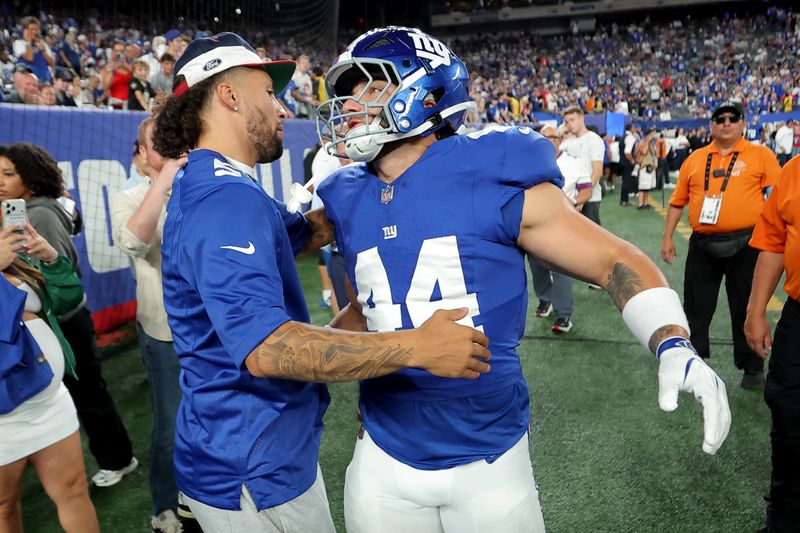 Sep 13, 2026; East Rutherford, New Jersey, USA; New York Knicks guard Jose Alvarado (left) greets New York Giants running back Cam Skattebo (44) during warmups before a game against the Dallas Cowboys at MetLife Stadium.
