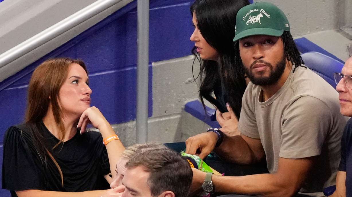 Hannah Berner, left, speaks with Ali Brunson as New York Knicks' Jalen Brunson sits next to her at a match between Ben Shelton, of the United States, and Frances Tiafoe, of the United States, during the men's singles semifinals of the U.S. Open tennis championships Friday, Sept. 11, 2026, in New York.