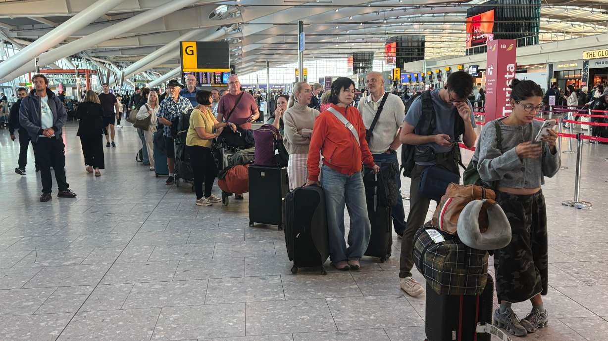 Passengers wait in line at Heathrow Airport in London, during an air traffic control problem that disrupted travel across Britain. A preliminary report on Friday blamed a millisecond-long software defect for the problem that led to over 2,000 flight cancellations.