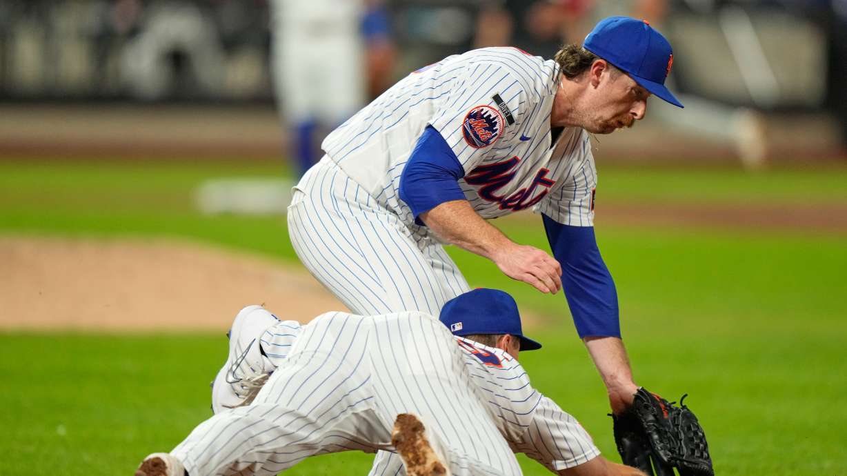 New York Mets pitcher Nolan McLean, top, collides with first baseman Jared Young as they chase a ball during the sixth inning of a baseball game against the Philadelphia Phillies, Thursday, Sept. 17, 2026, in New York.