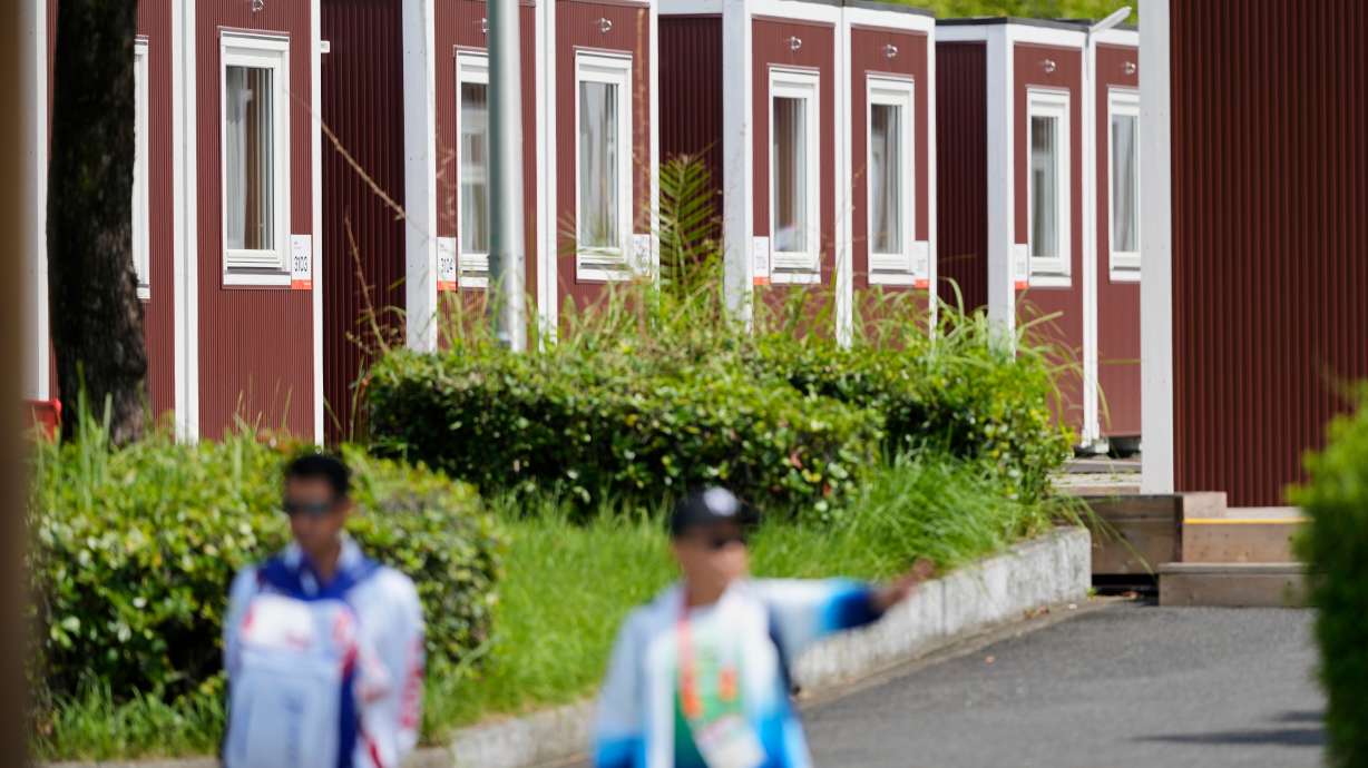 Officials stand outside the athletes accommodation huts at the Athletes Village ahead of the Asian Games Nagoya, Japan, Friday, Sept. 18, 2026.