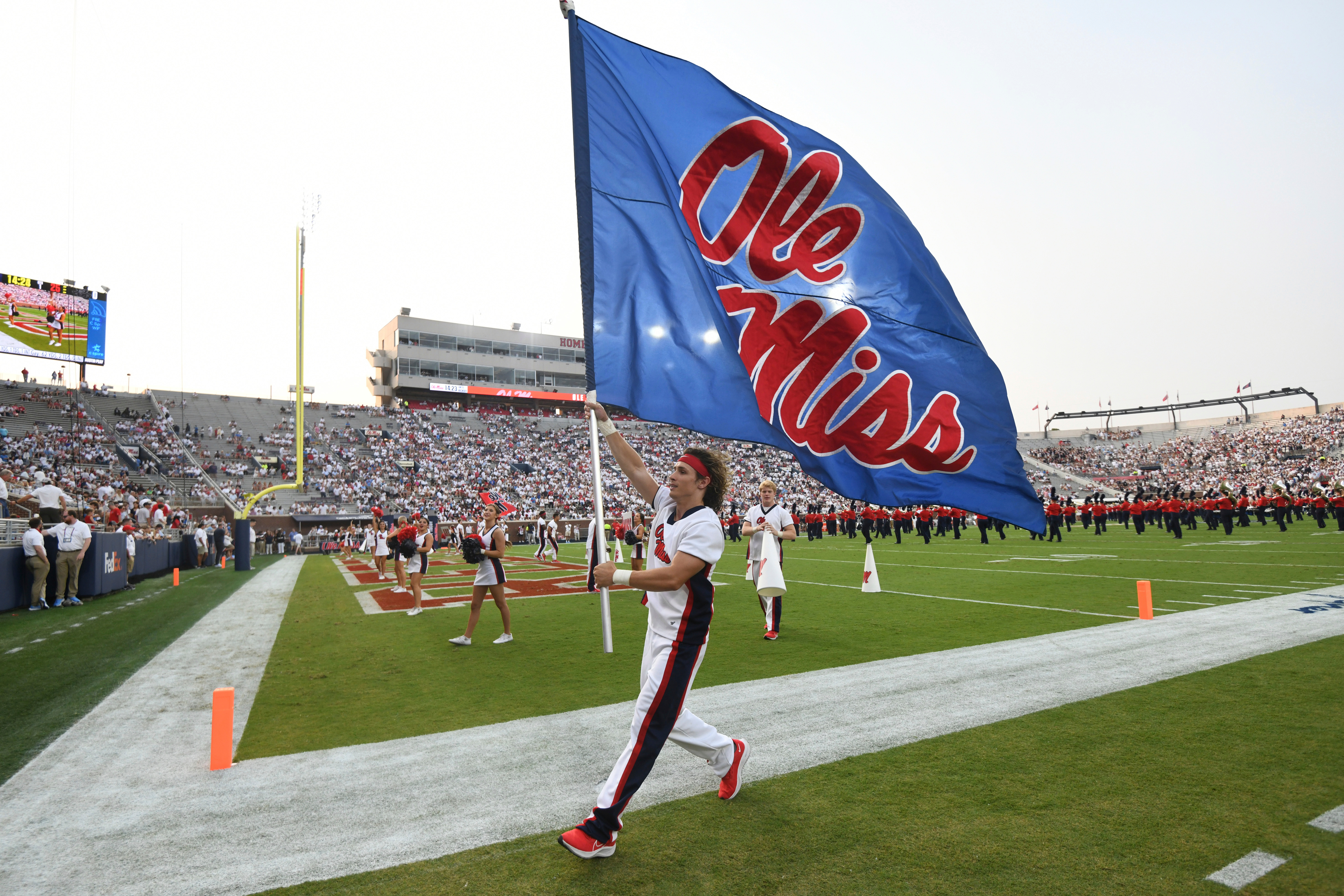FILE - A cheerleader runs with a flag during an NCAA college football game between Mississippi and Austin Peay at Vaught-Hemingway Stadium in Oxford, Miss., Sept. 11, 2021. 