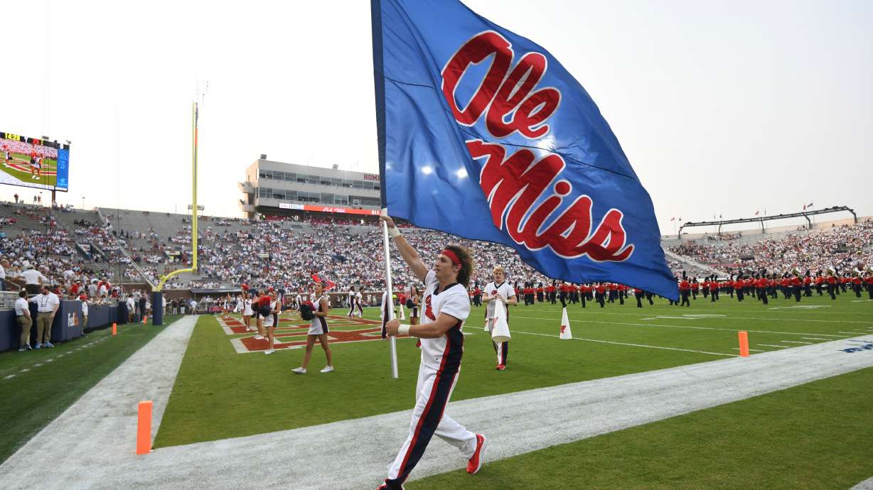 FILE - A cheerleader runs with a flag during an NCAA college football game between Mississippi and Austin Peay at Vaught-Hemingway Stadium in Oxford, Miss., Sept. 11, 2021.