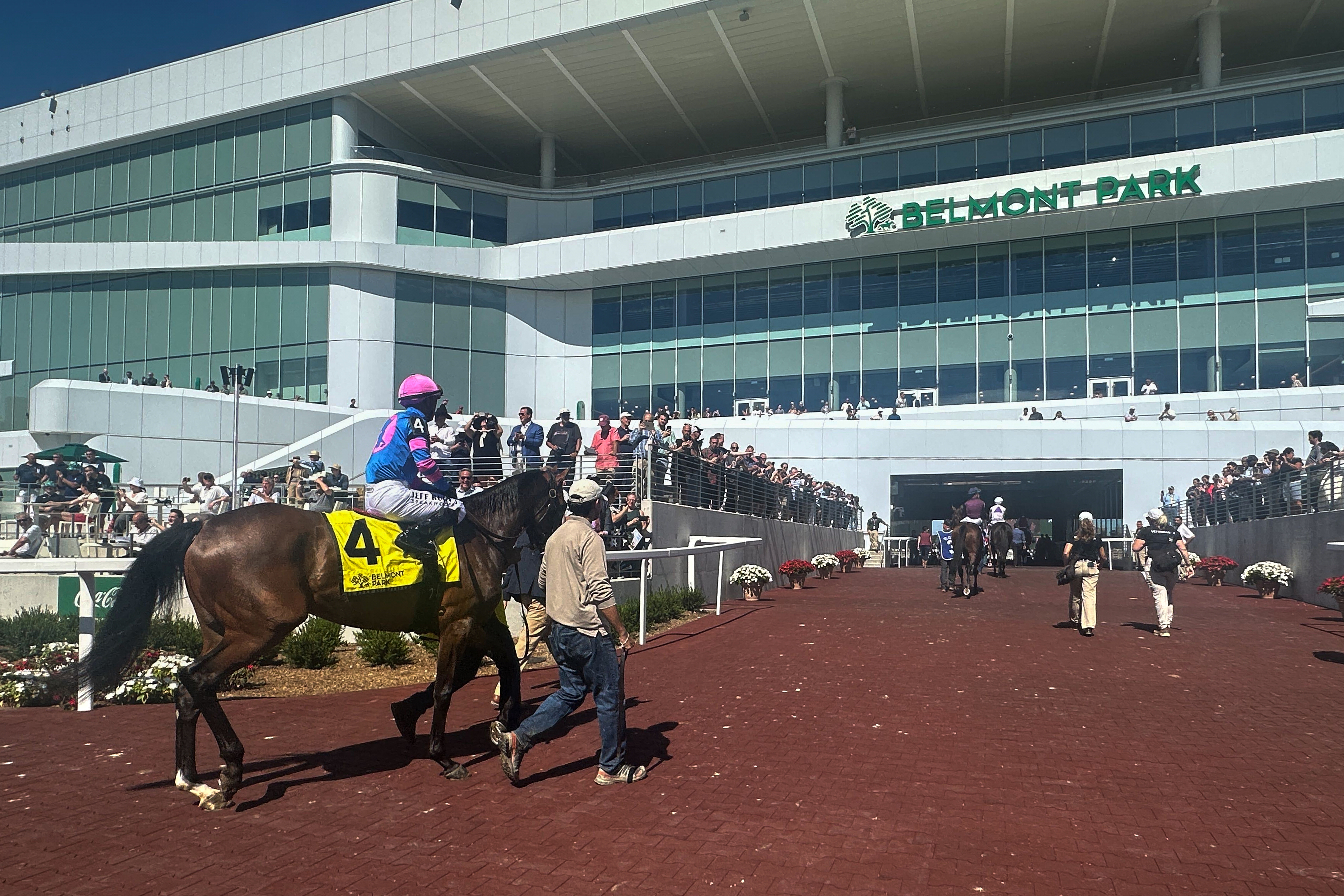 In this photo made with a smartphone, jockeys ride their horses into the newly-opened Belmont Park in Elmont, N.Y., on Friday, Sept. 18, 2026. 