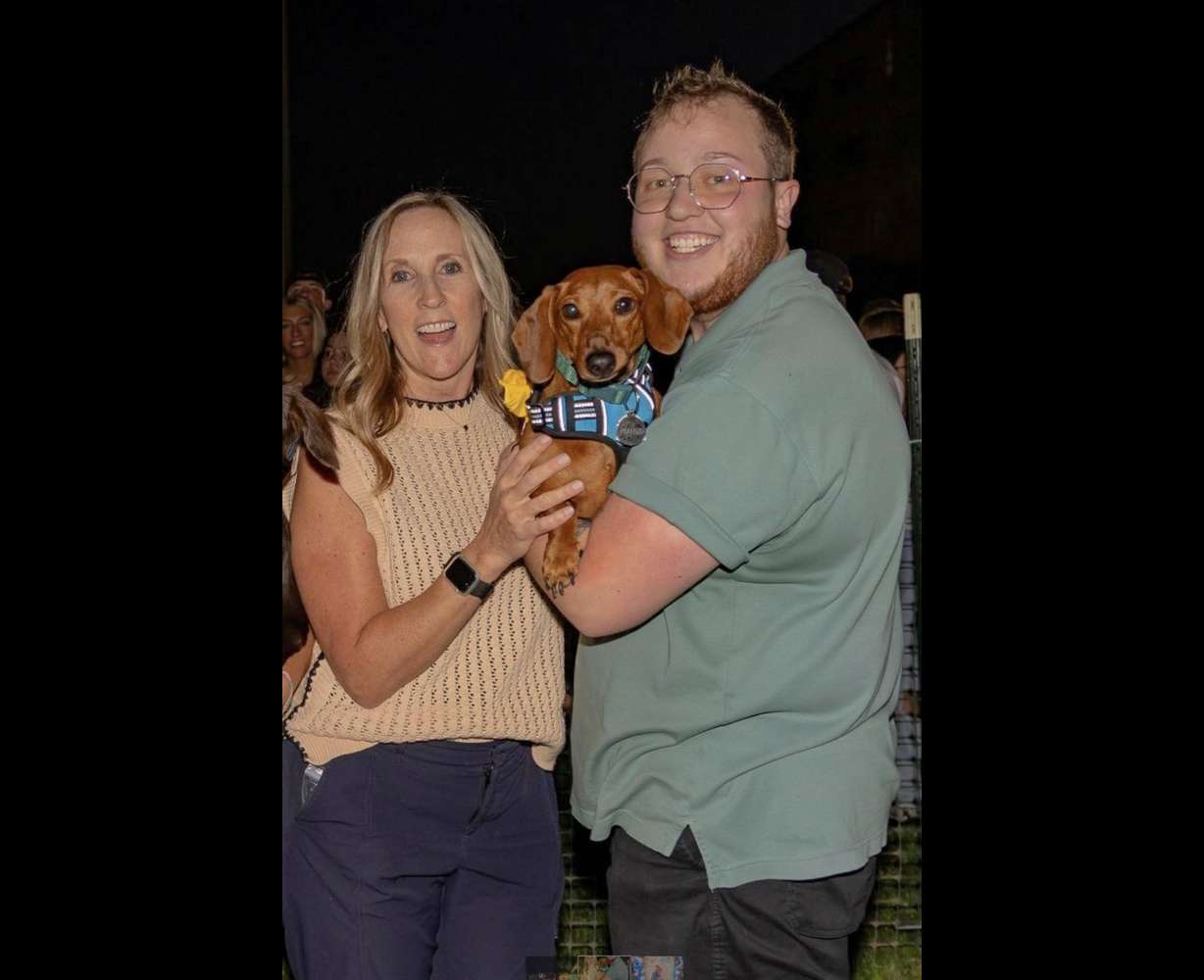 Stacy Schmidt and Ry Iverson pose with Peanut during the 2025 Weenie Mania at Utah Tech University.