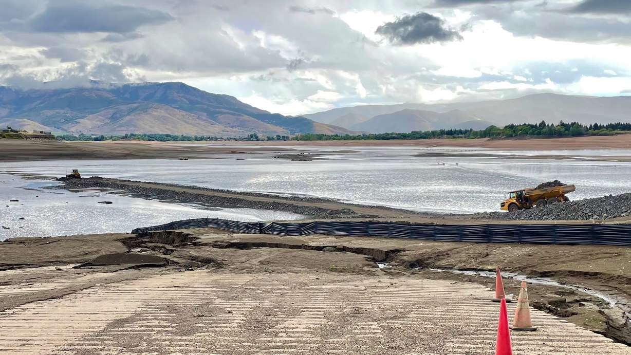 A truck hauls material to build up a temporary road across Pineview Reservoir in Weber County on Friday. The roadway will be used to help install a new section of water pipeline crossing the reservoir.