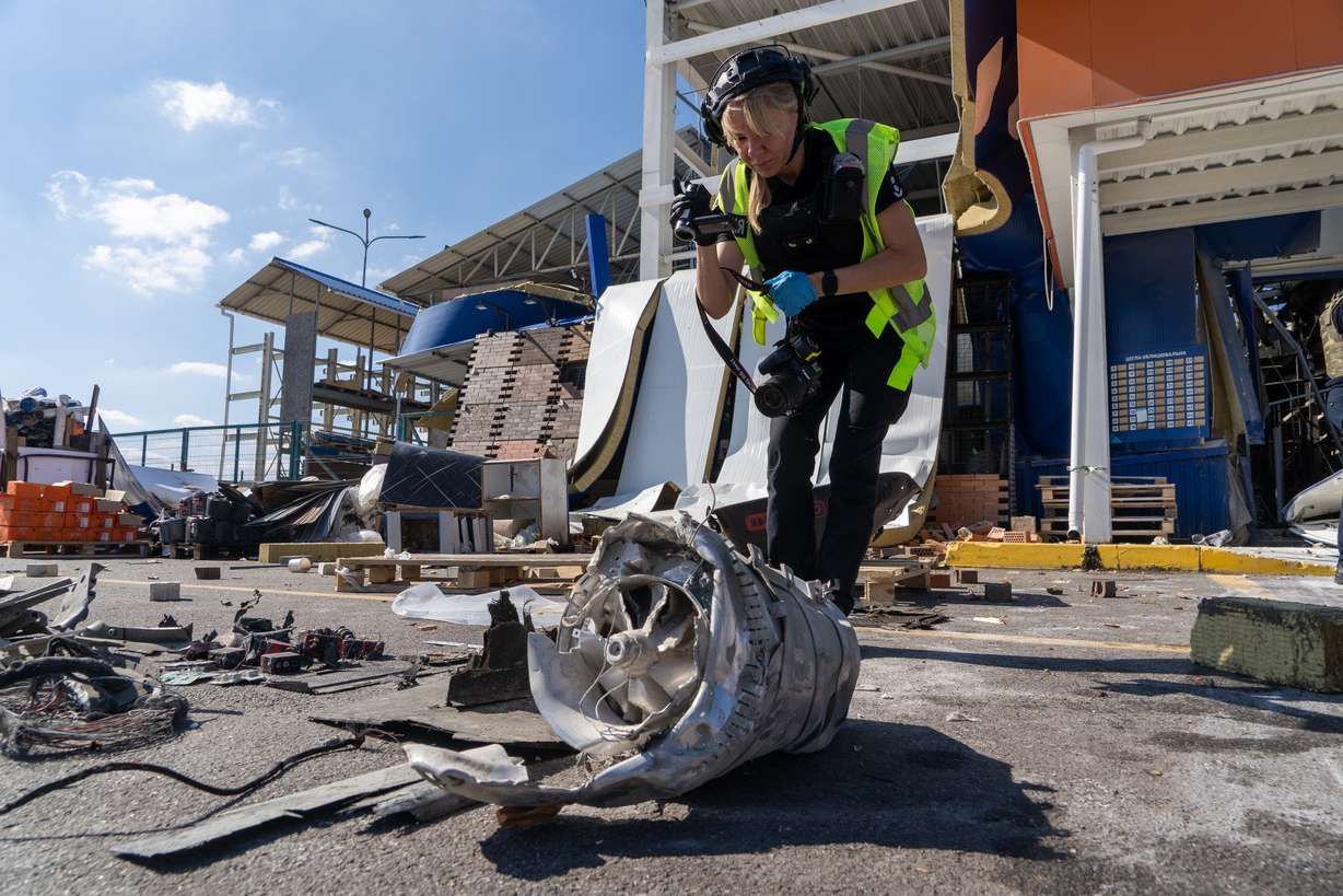 A police officer inspects fragments of a Russian drone after an air attack on a commercial infrastructure in Kharkiv, Ukraine, on Thursday.