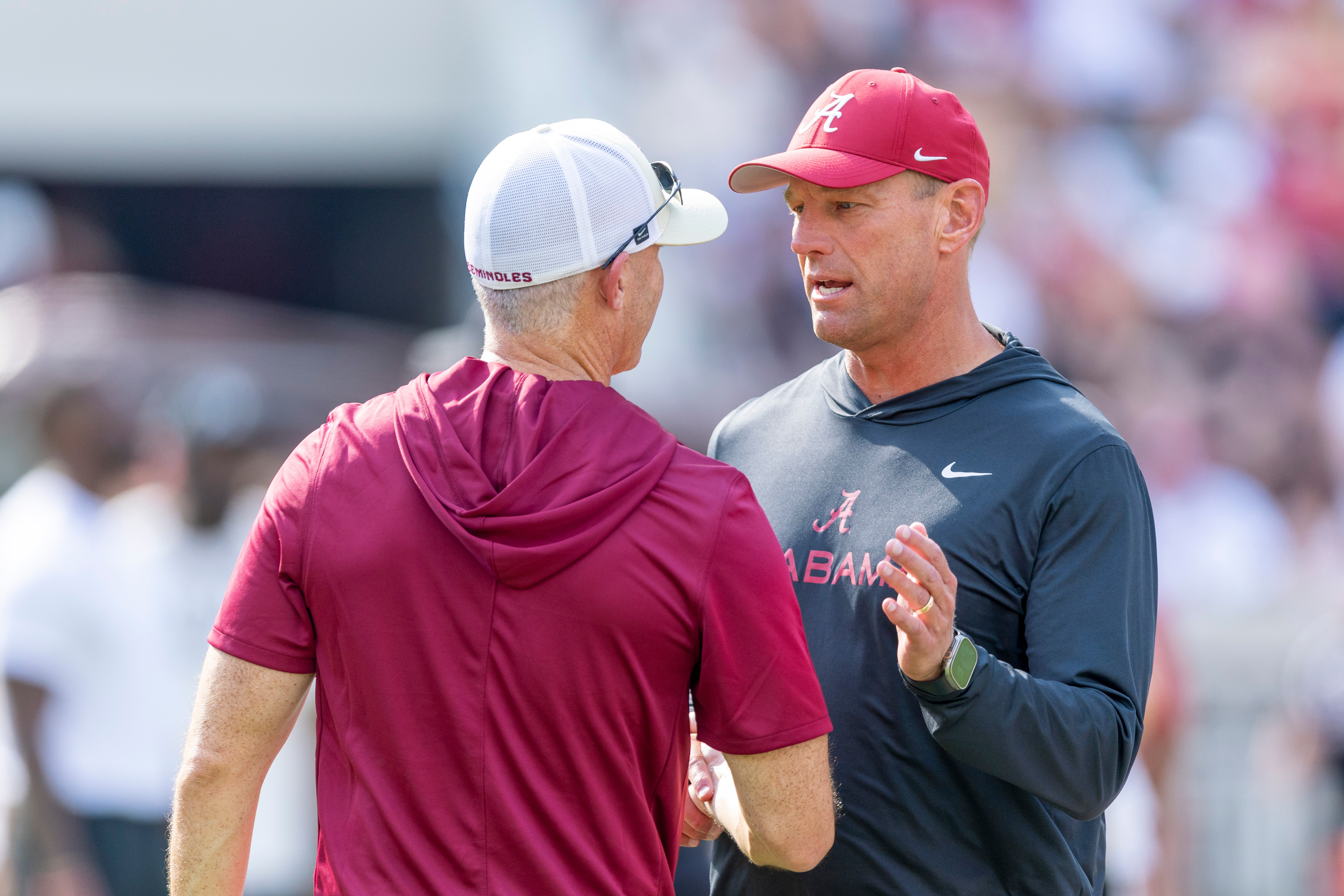 Alabama head coach Kalen DeBoer, right, meets with Florida State head coach Mike Norvell, left, before an NCAA college football game Saturday, Sept. 19, 2026, in Tuscaloosa, Ala. 