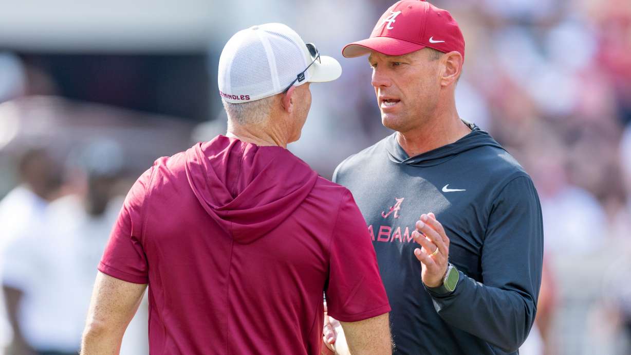 Alabama head coach Kalen DeBoer, right, meets with Florida State head coach Mike Norvell, left, before an NCAA college football game Saturday, Sept. 19, 2026, in Tuscaloosa, Ala.