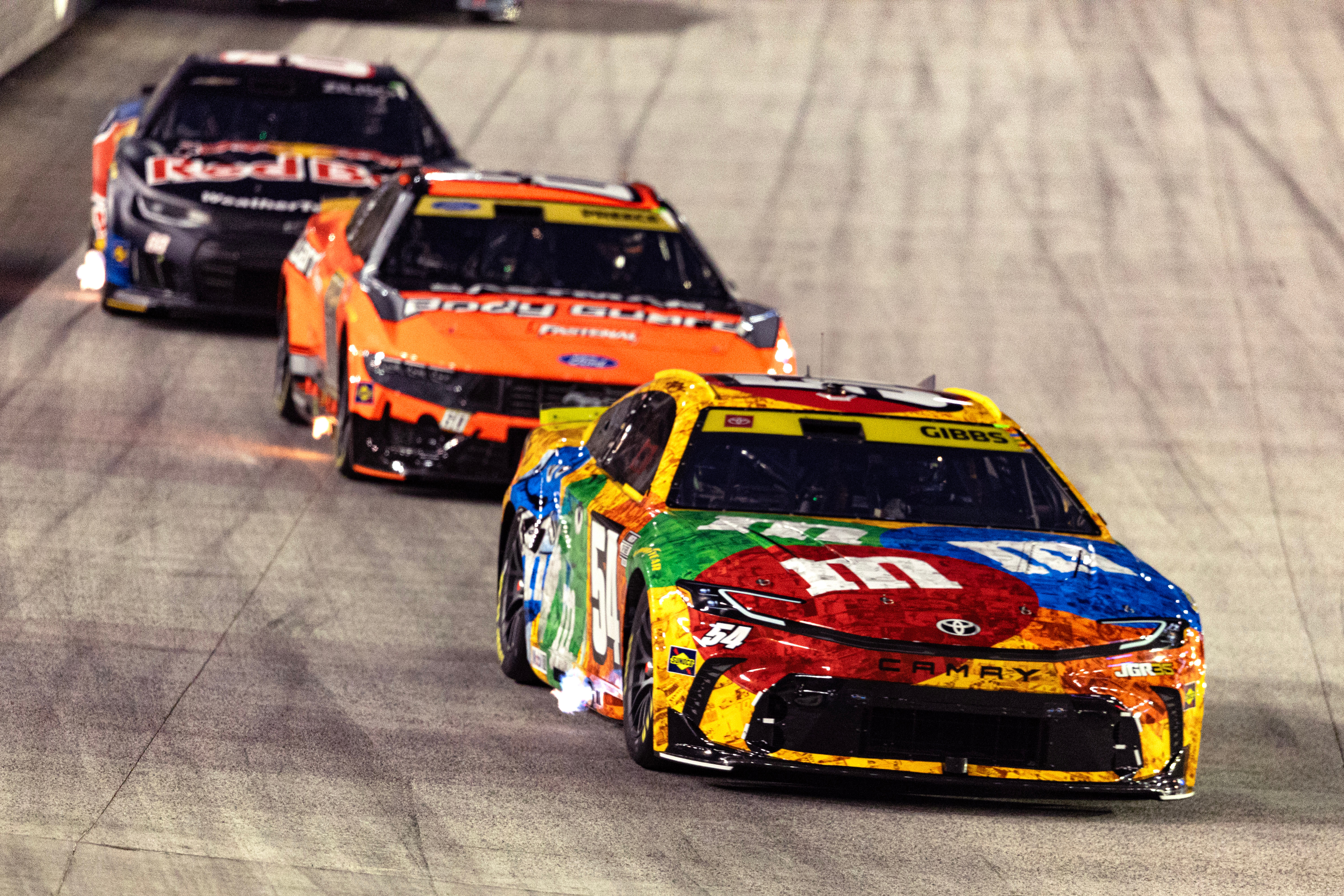 Ty Gibbs (54), in the throwback M&M's car honoring the late Kyle Busch, leads Ryan Preece and Connor Zilisch during a NASCAR Cup Series auto race Saturday, Sept. 19, 2026, in Bristol, Tenn. 