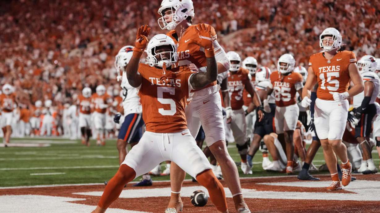 Texas running back Derrek Cooper (5) and Arch Manning, rear, celebrate after Cooper ran the ball for a touchdown during the second half of an NCAA college football game against UTSA in Austin, Texas, Saturday, Sept. 19, 2026.